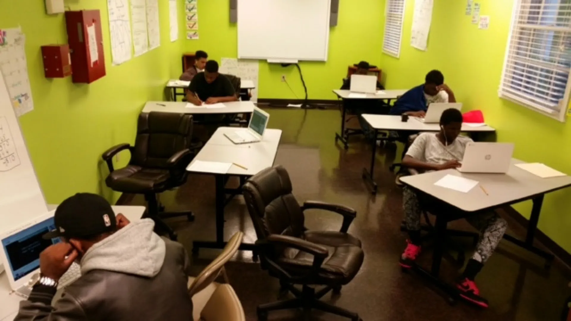 a group of people sitting at desks in a classroom
