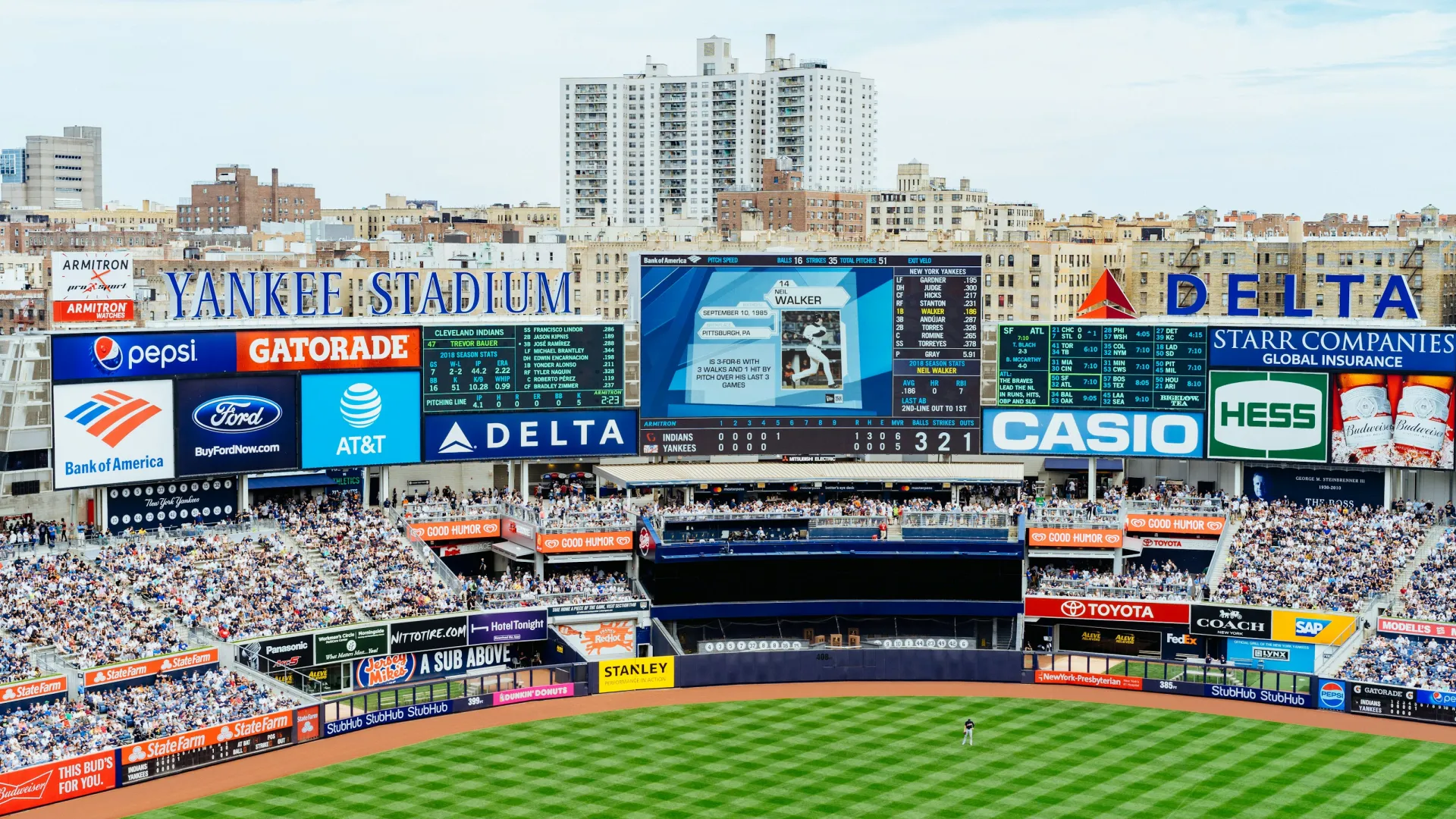 Yankee Stadium baseball field with players, scoreboard, and crowded stands in New York City.