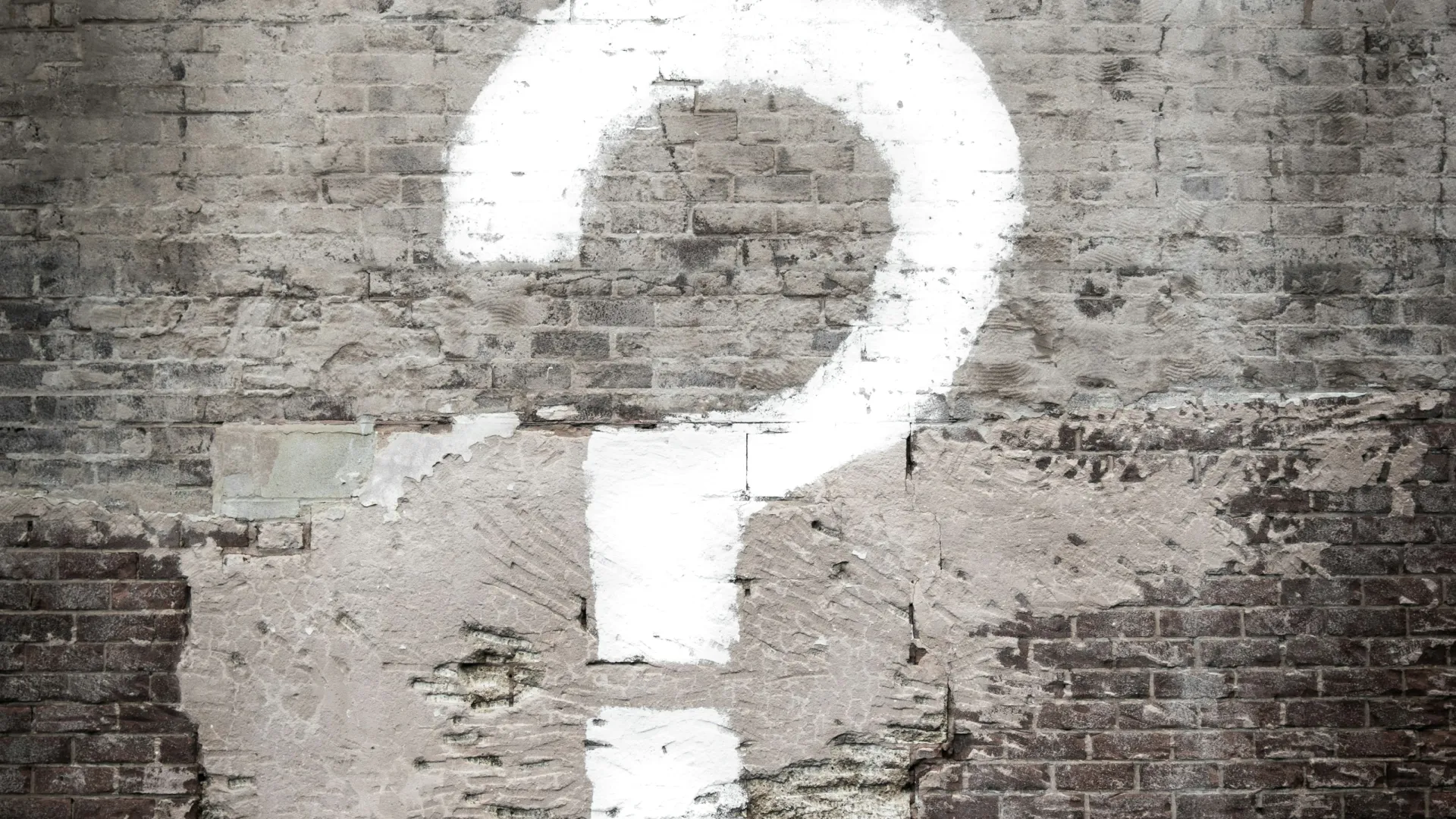 White question mark graffiti painted on an old brick wall above a Smith Street sign on the sidewalk.