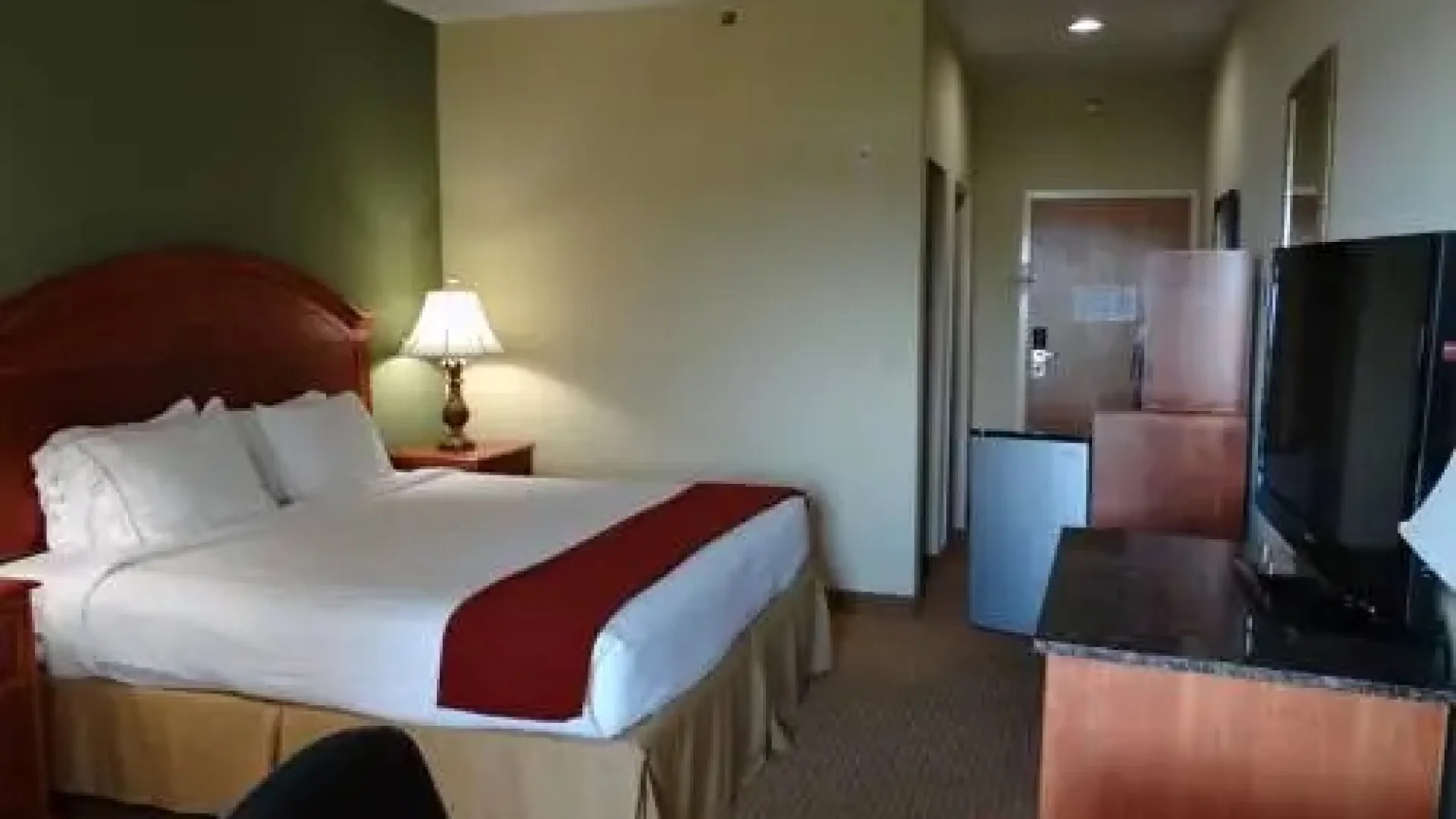 a hotel room with a bed desk and a tv