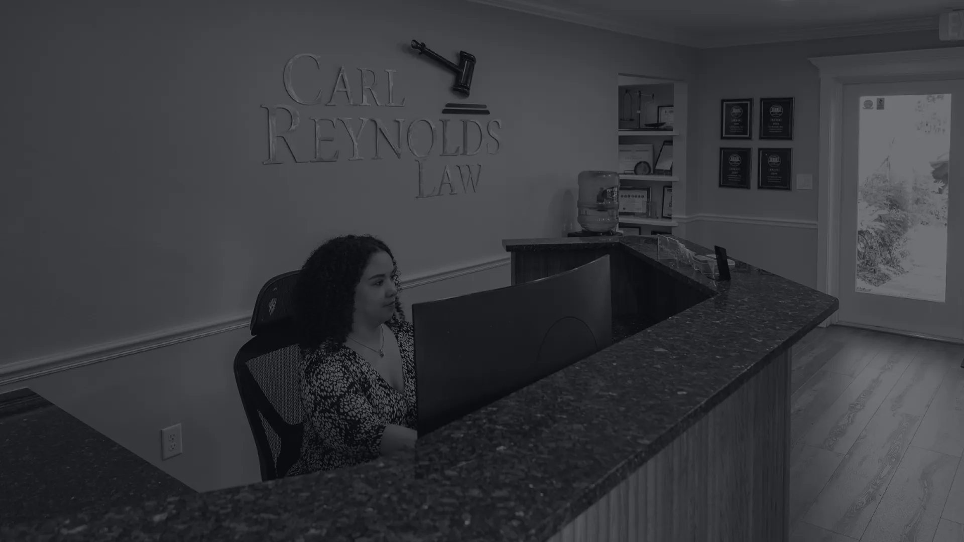 Reception area of Carl Reynolds Law with receptionist at desk and visible office entrance and decor.
