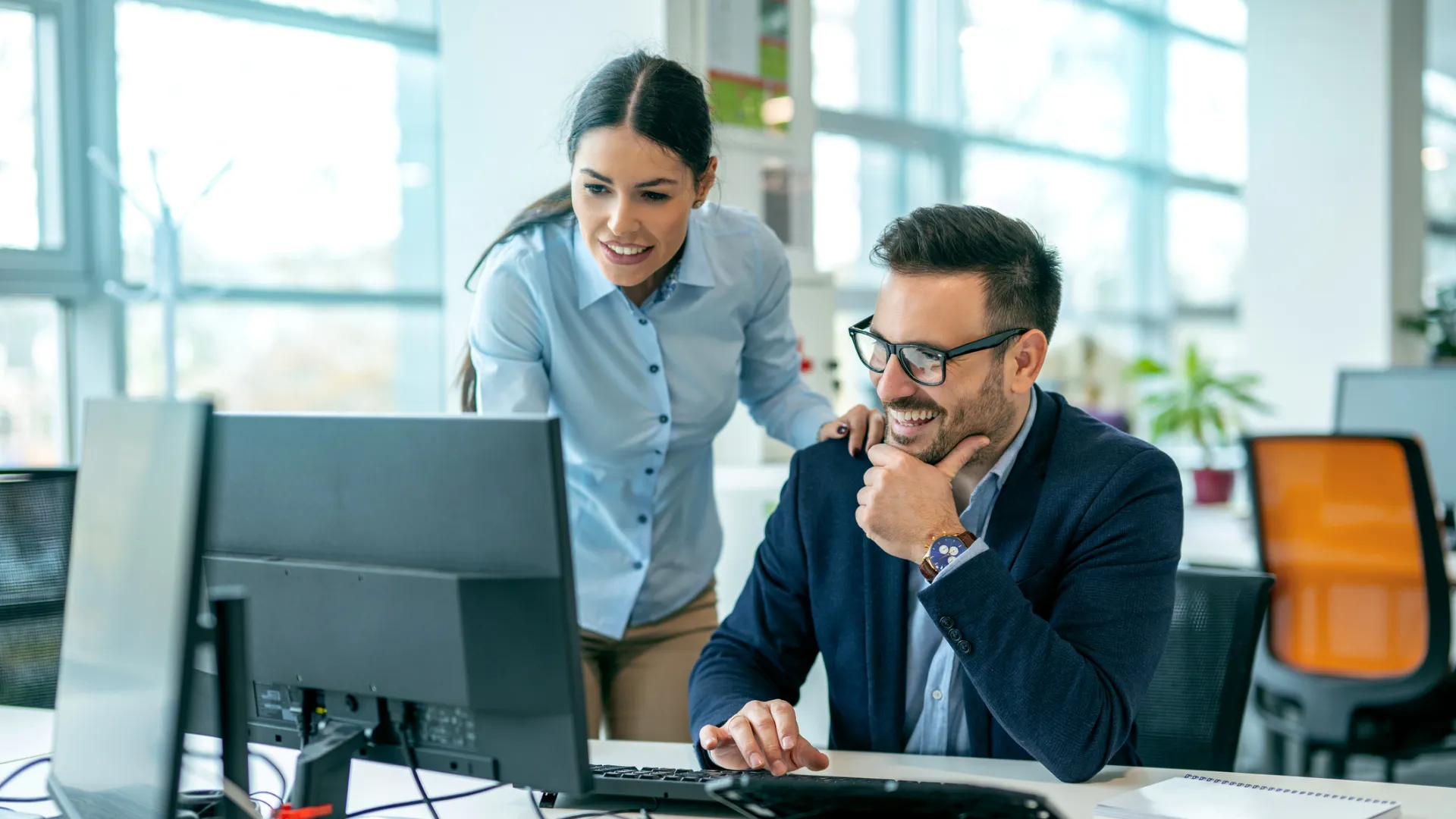 a man and a woman looking at a computer screen