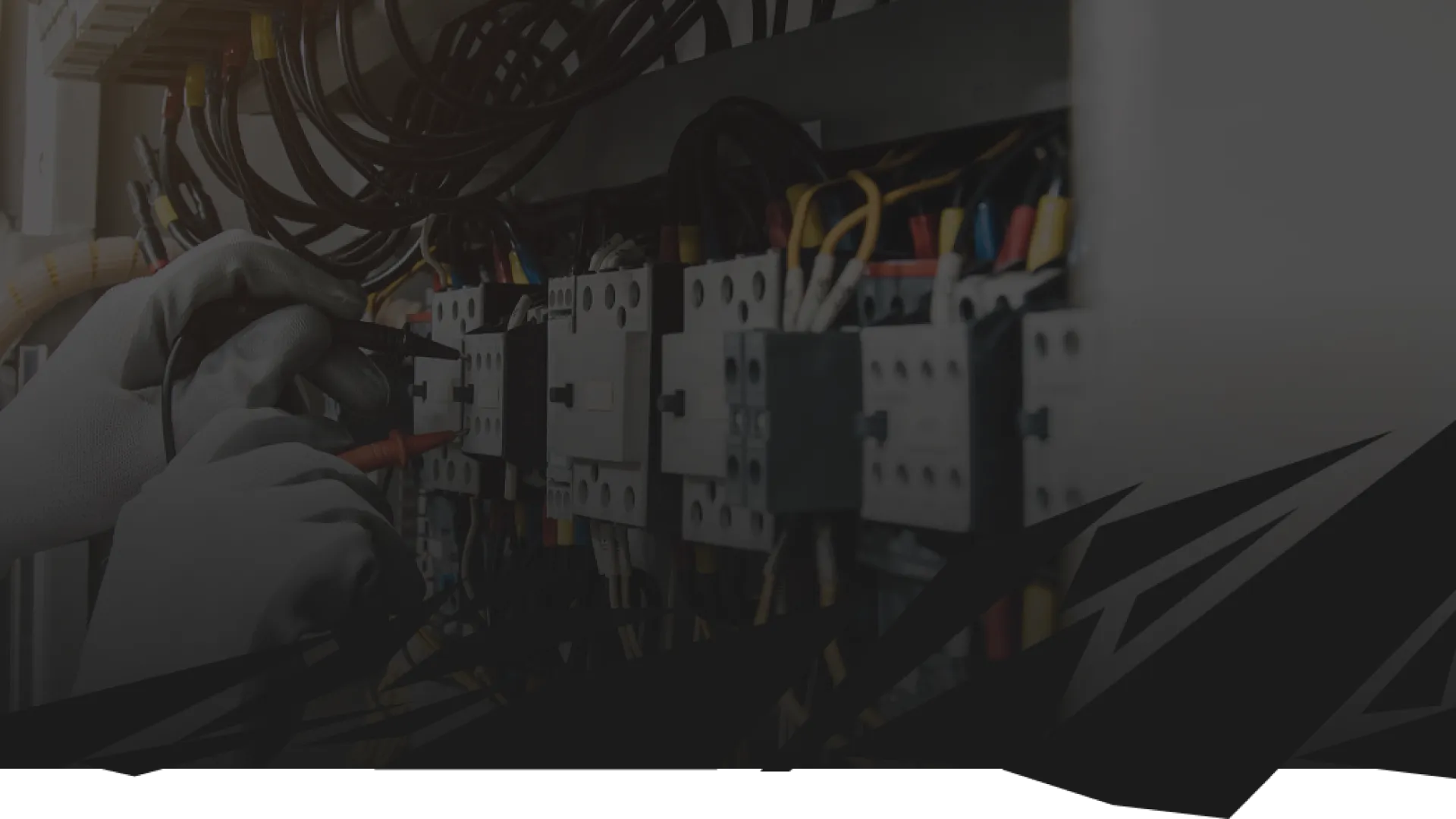 Electrician in white gloves working on a complex electrical control panel with multiple wires and components.