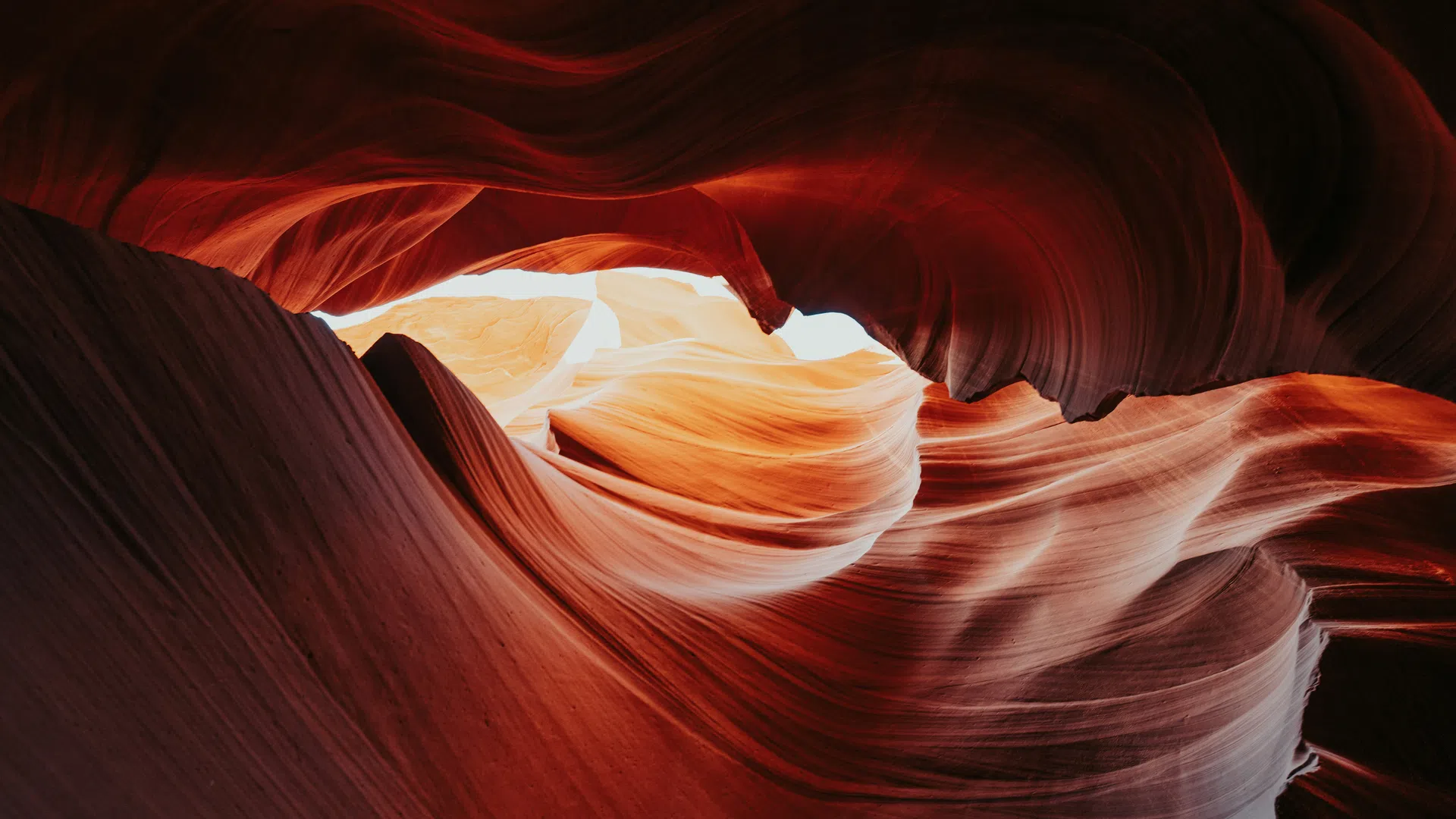 Curved red sandstone walls inside Antelope Canyon illuminated by natural light from above.