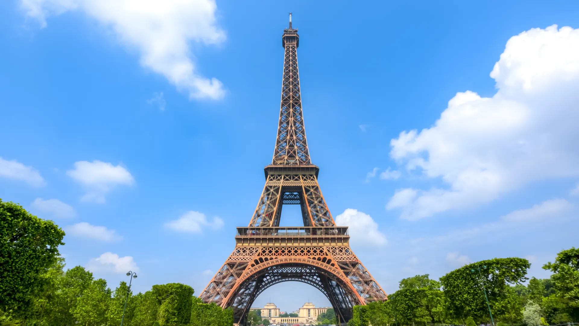 a tall metal tower with Eiffel Tower in the background