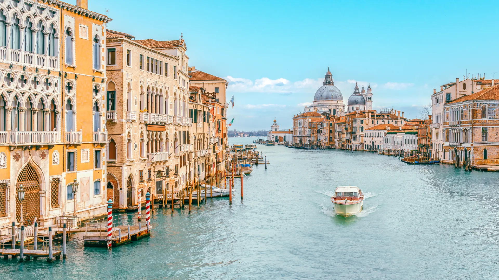 a river with boats in it and buildings around it with Grand Canal in the background