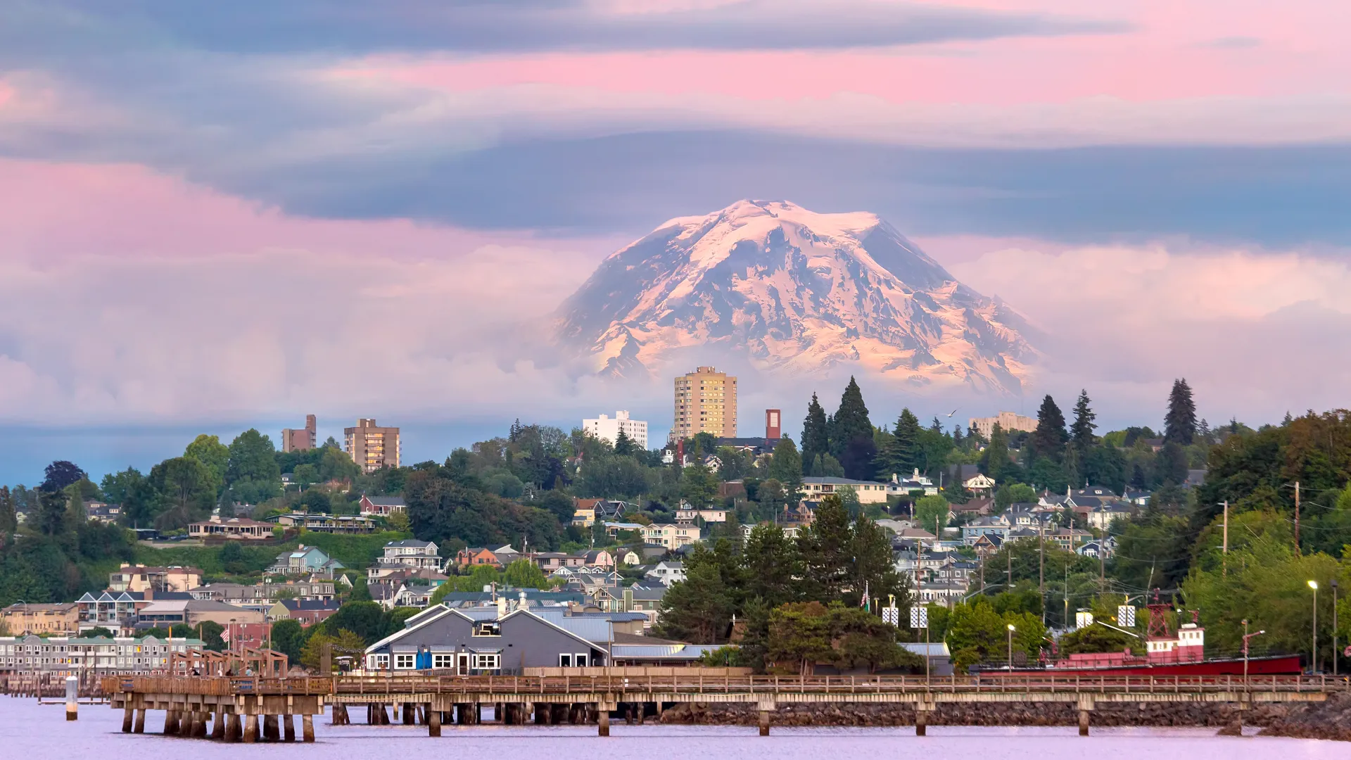 a city next to a body of water with a mountain in the background