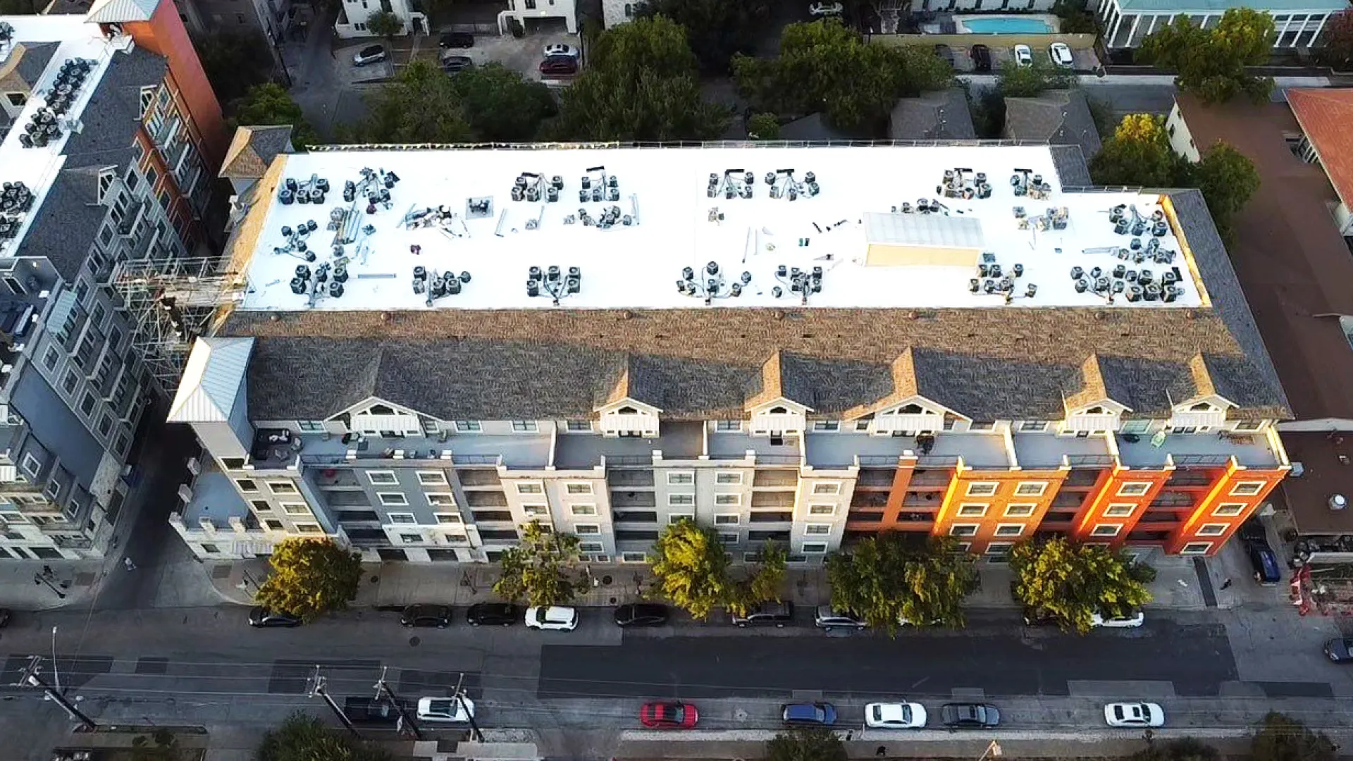 Aerial drone view of TPO flat roof installation in progress on The Block on 25th East student housing complex by Mattco Roofing and Construction
