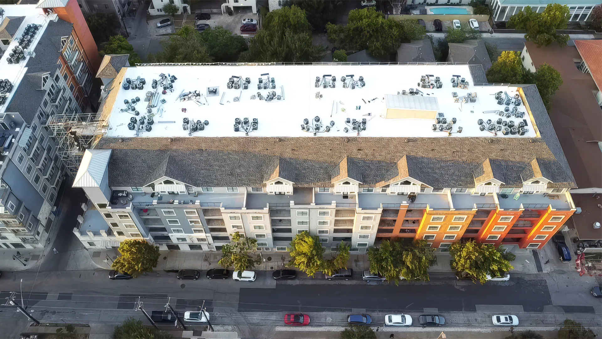 Aerial drone view of TPO flat roof installation in progress on The Block on 25th East student housing complex by Mattco Roofing and Construction