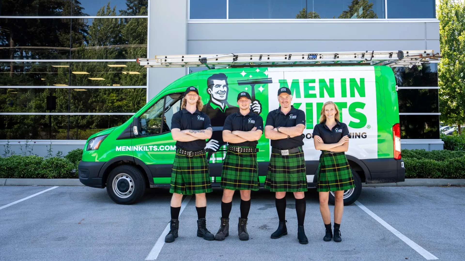 a group of women in kilts standing in front of a green van