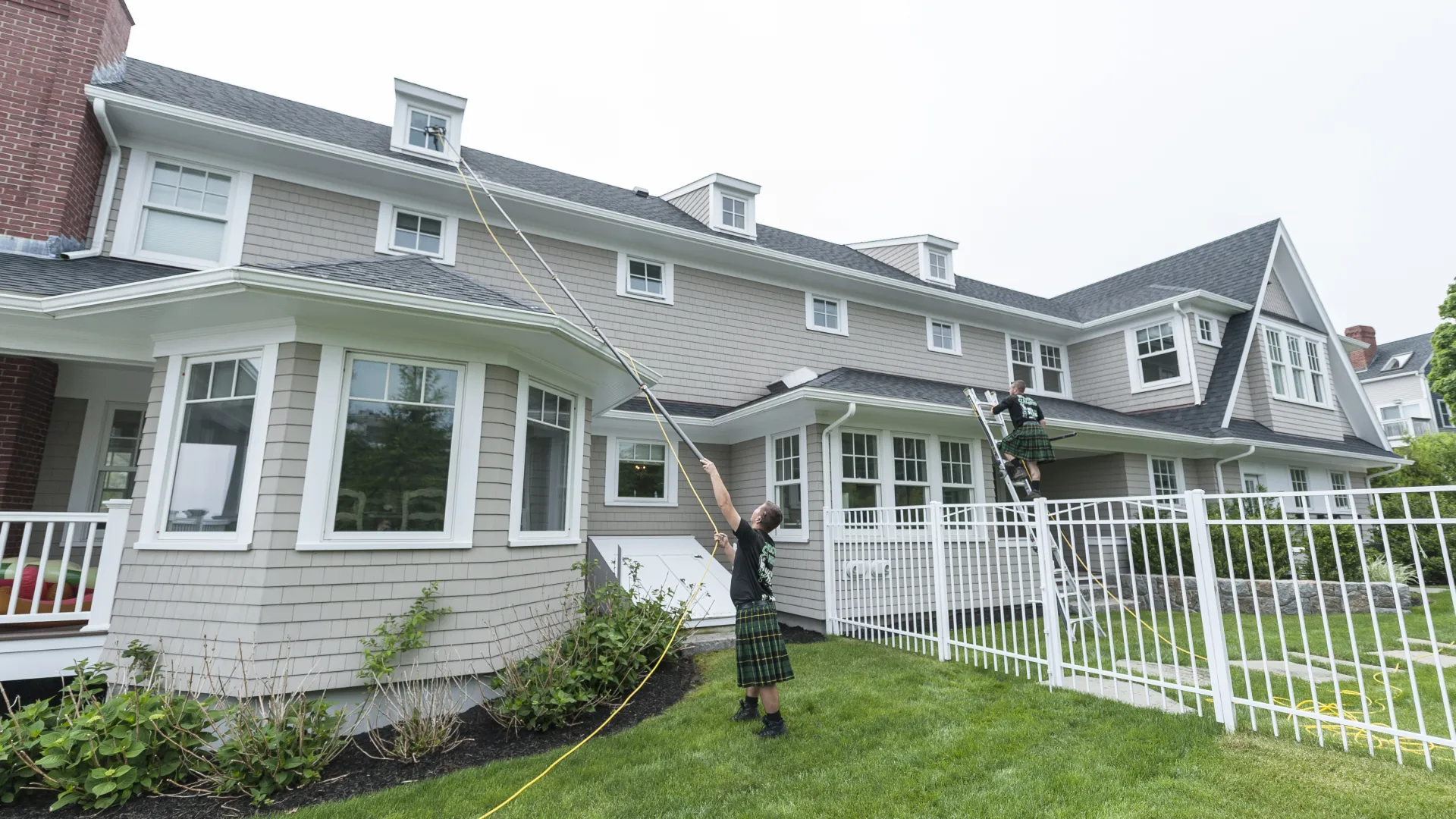 a person standing on a lawn with a rope in front of a house