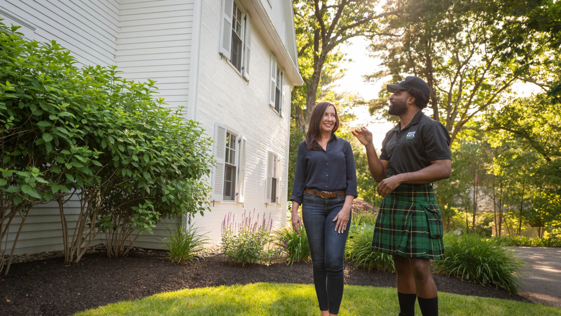 a man and woman standing in front of a house