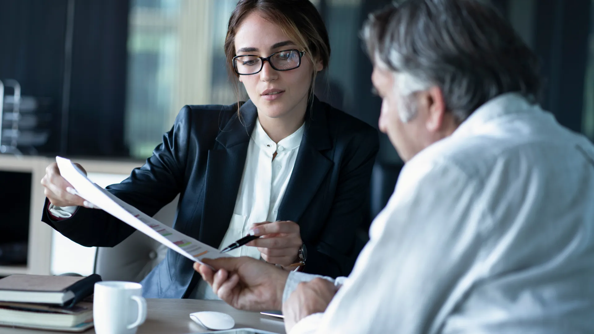 a woman showing a man something on the paper