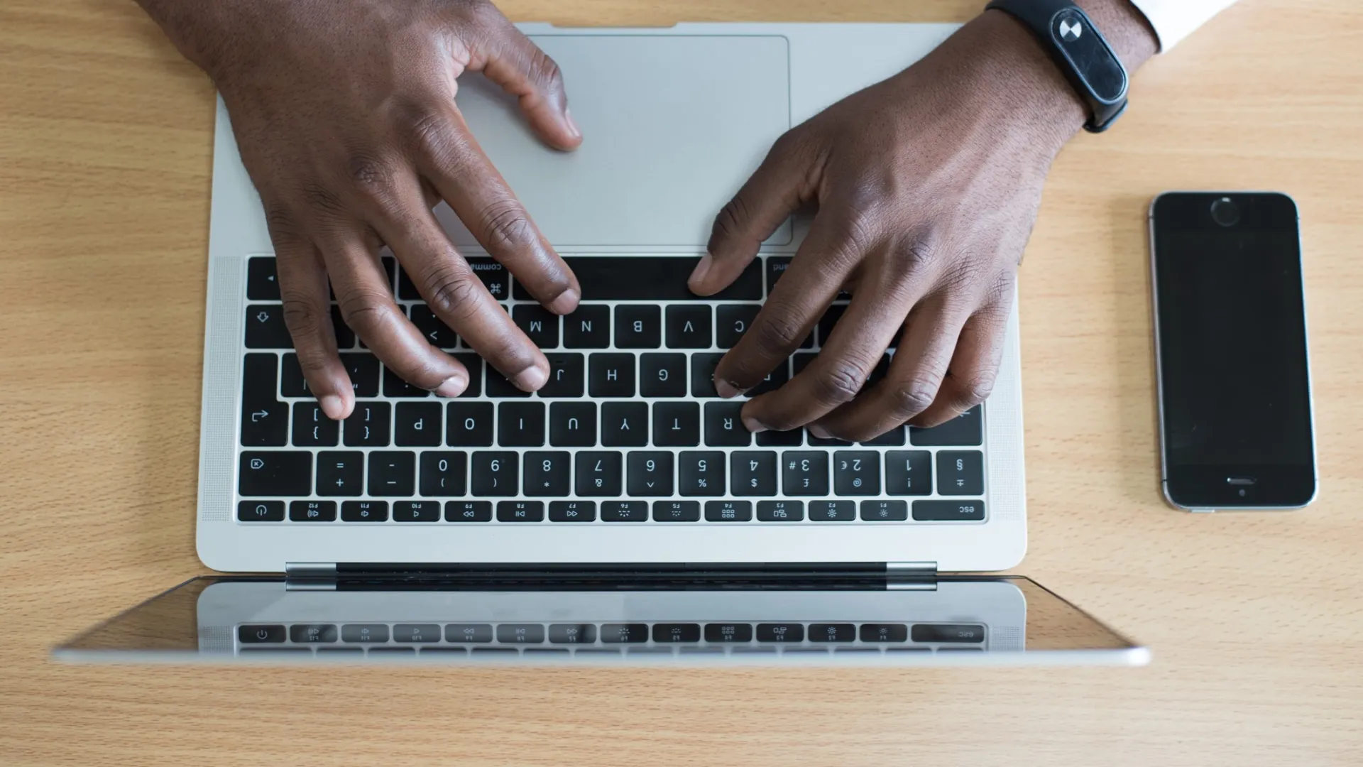 a man using a laptop computer sitting on top of a table