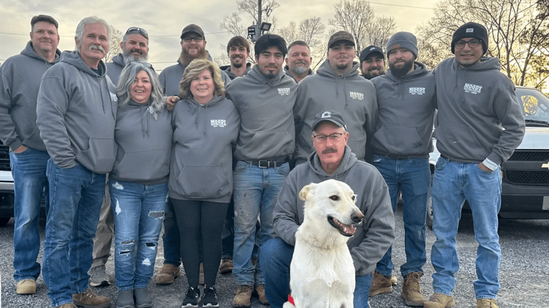 a group of people posing for a photo with a dog
