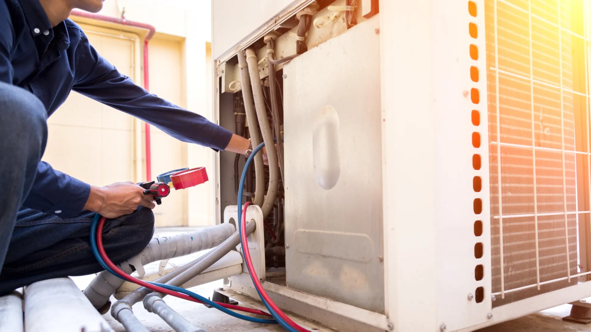 Technician inspecting and repairing an air conditioning unit with diagnostic tools and colorful hoses in Dallas, GA