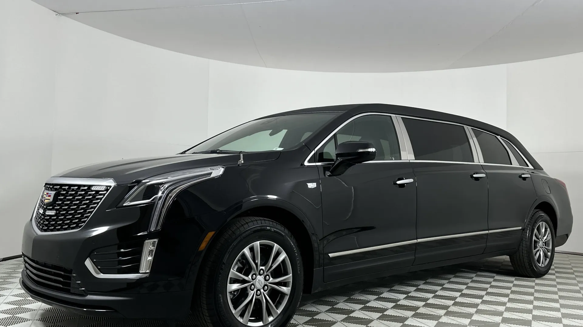 Black Cadillac XT5 SUV displayed in a showroom with a modern background.