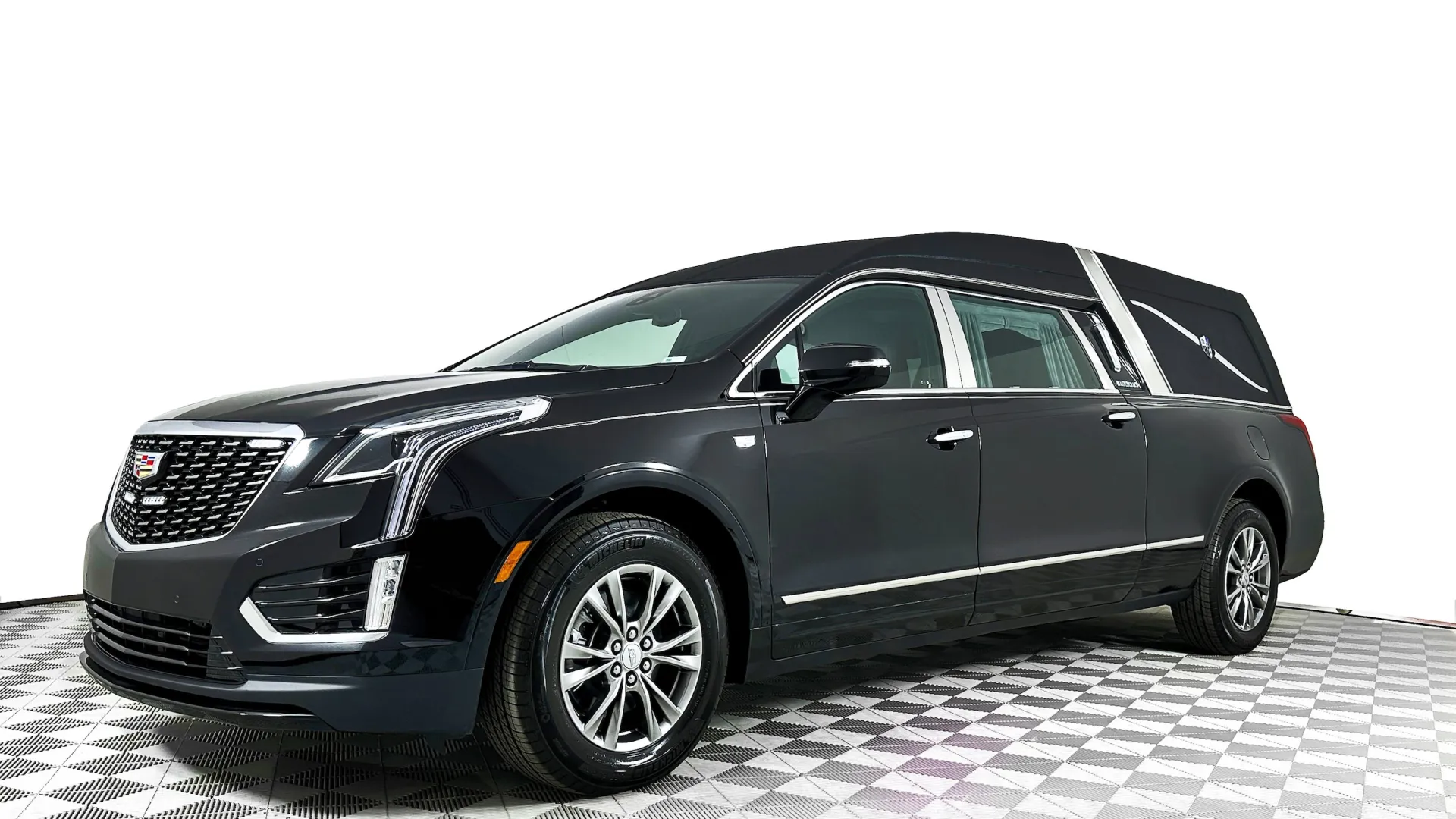 Elegant black Cadillac hearse with sleek design and modern features on a checkered floor.