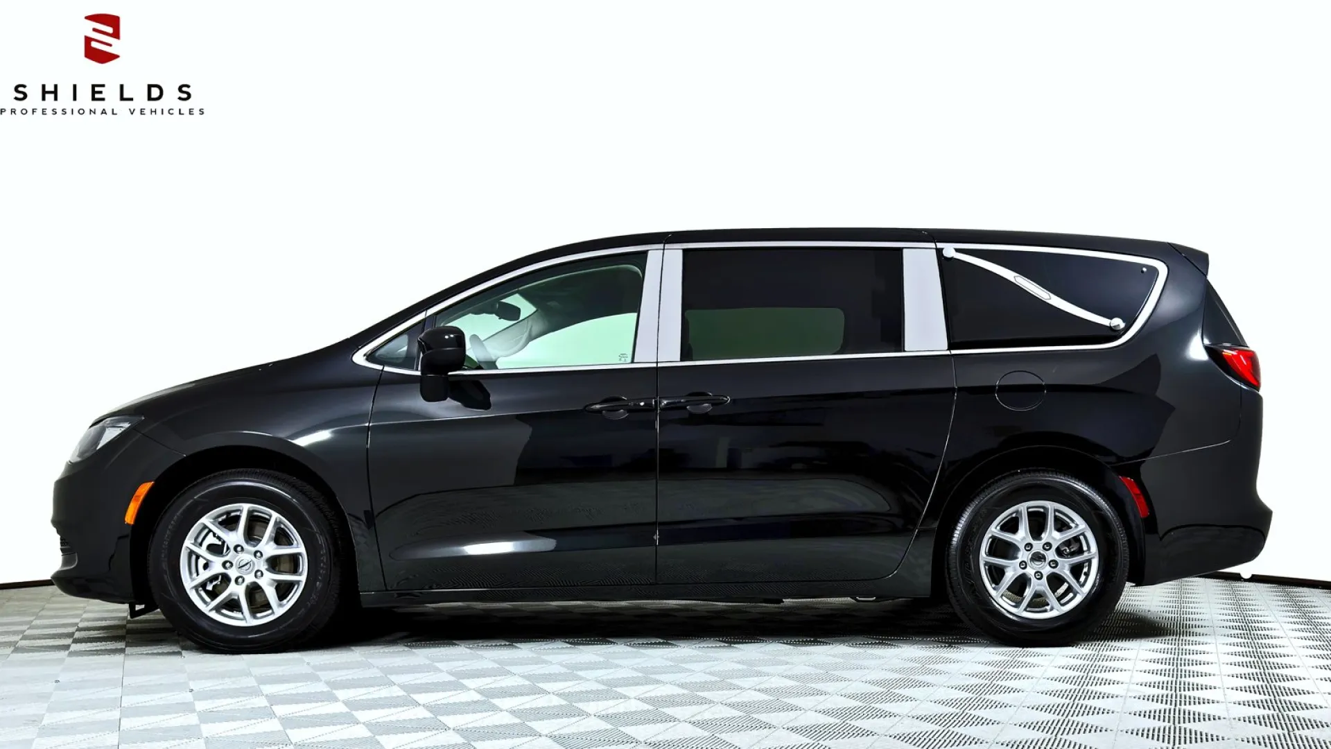 A sleek black minivan side view against a white background showcasing its modern design.