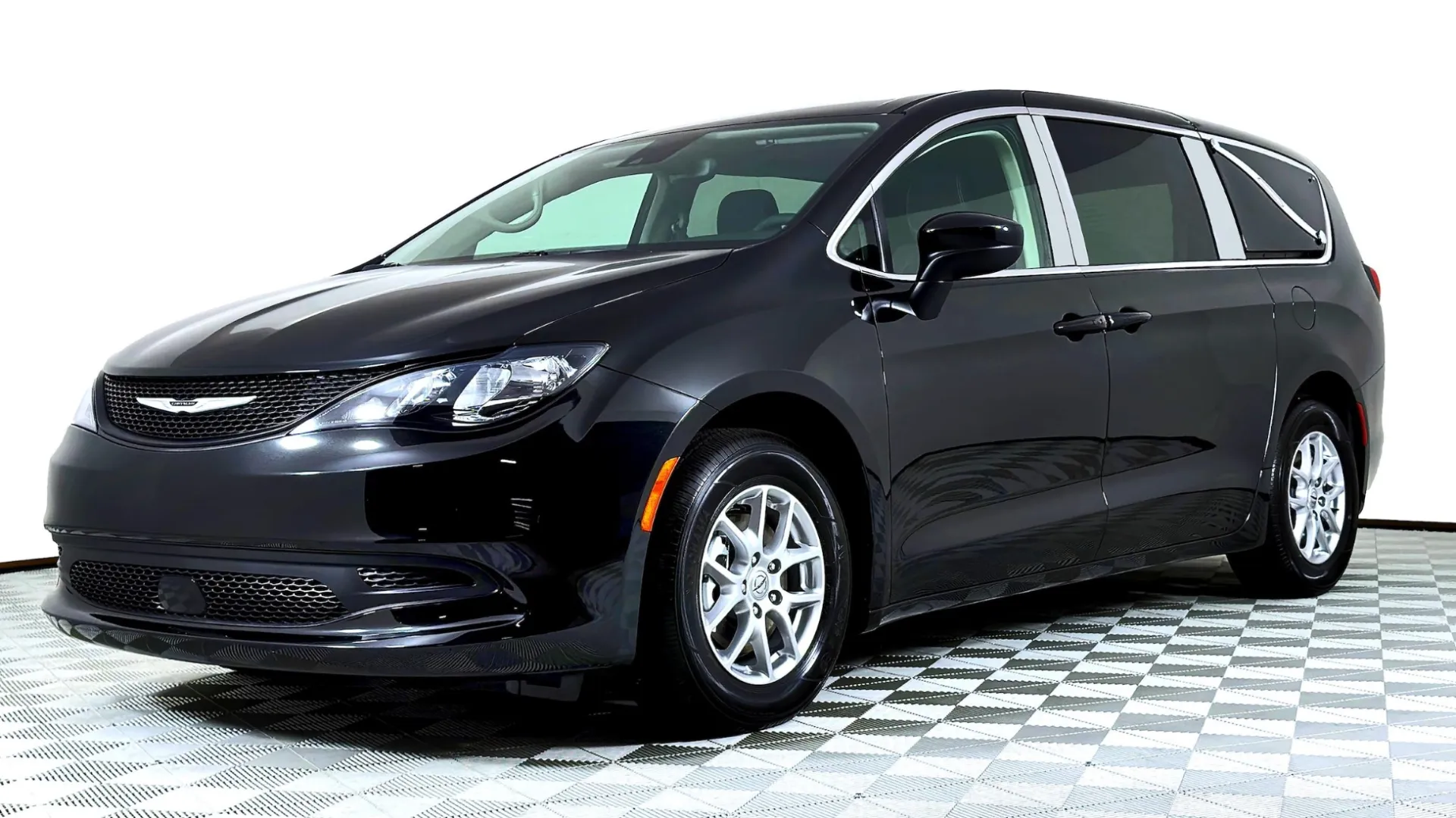 Black Chrysler minivan parked in a studio with a clean background showcasing its sleek design.