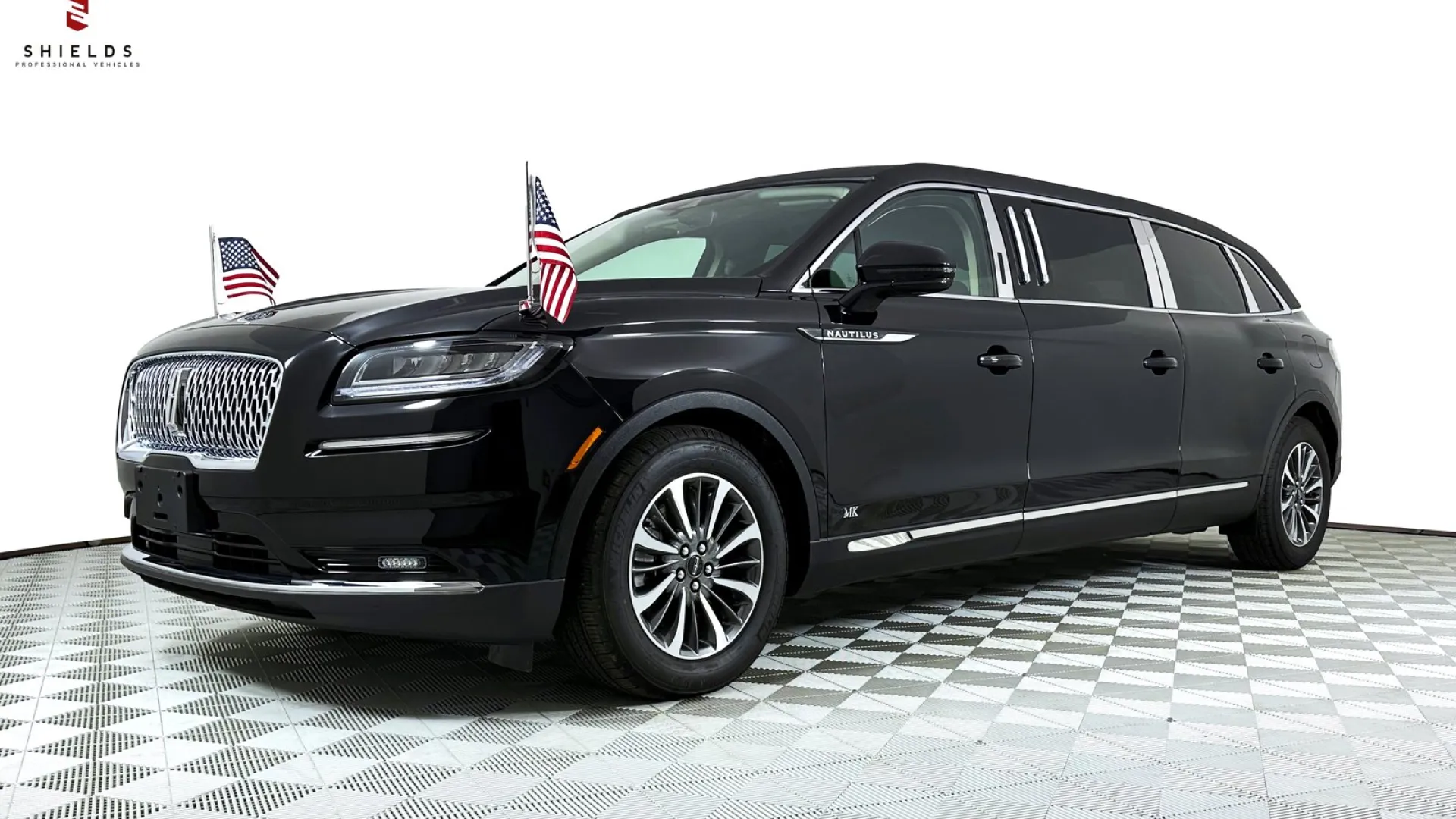 Black luxury limousine with two American flags on the front, showcasing elegance and style.