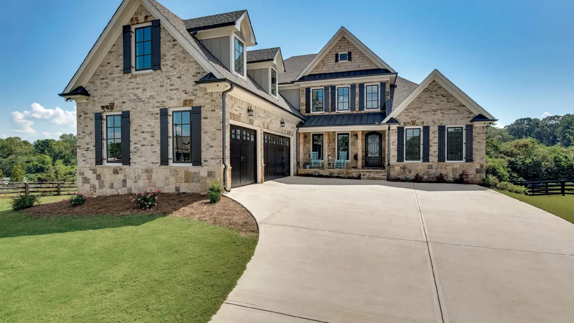 a large stone house with Infinity Windows and shutters installed by North Georgia Replacement Windows