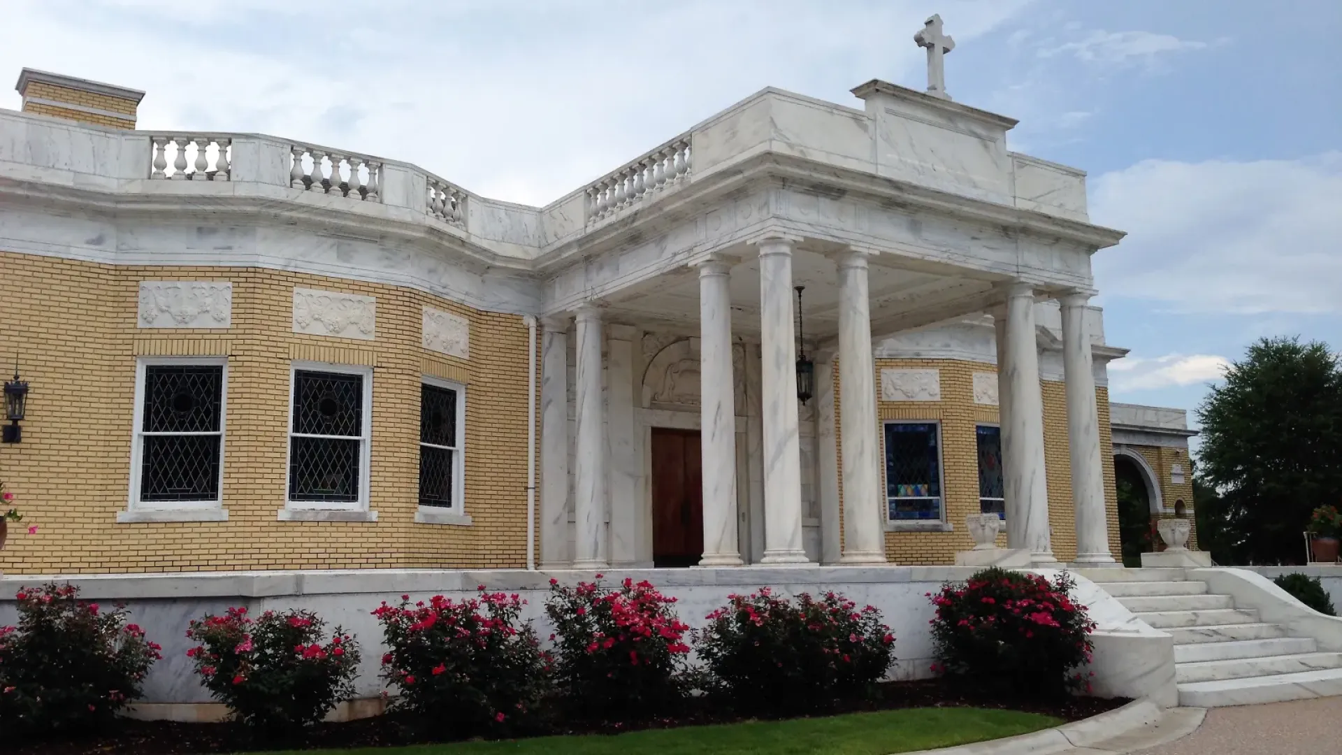 a building with pillars and a lawn