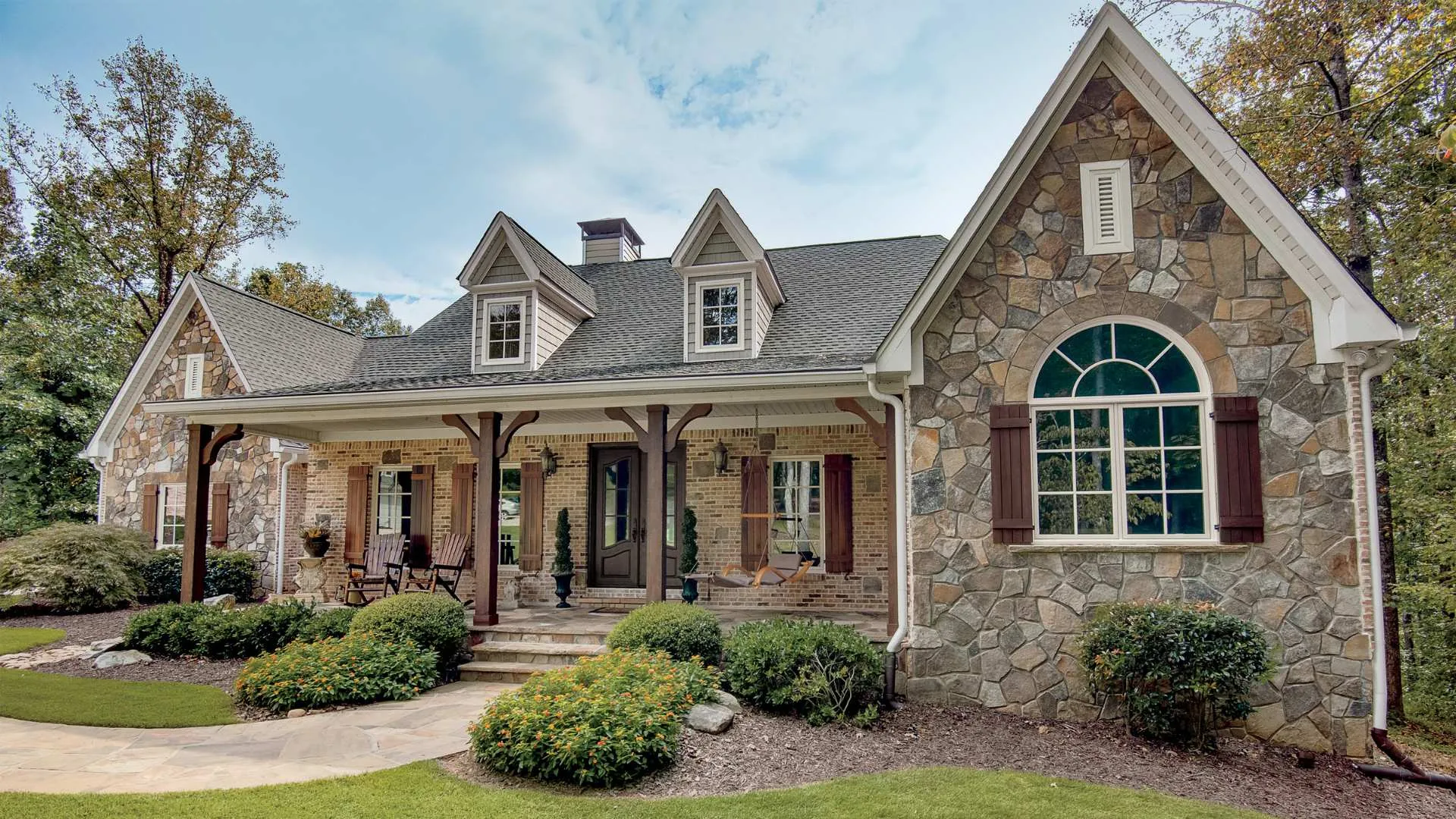 a stone house with a large front yard