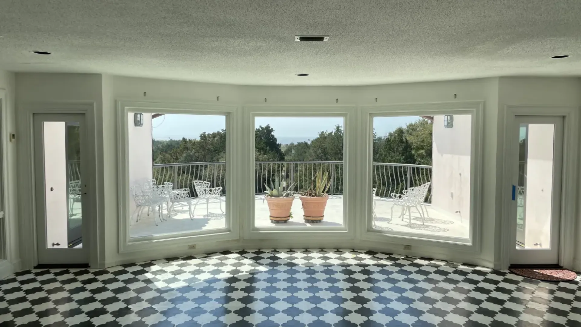 a room with a large window and a rug in it