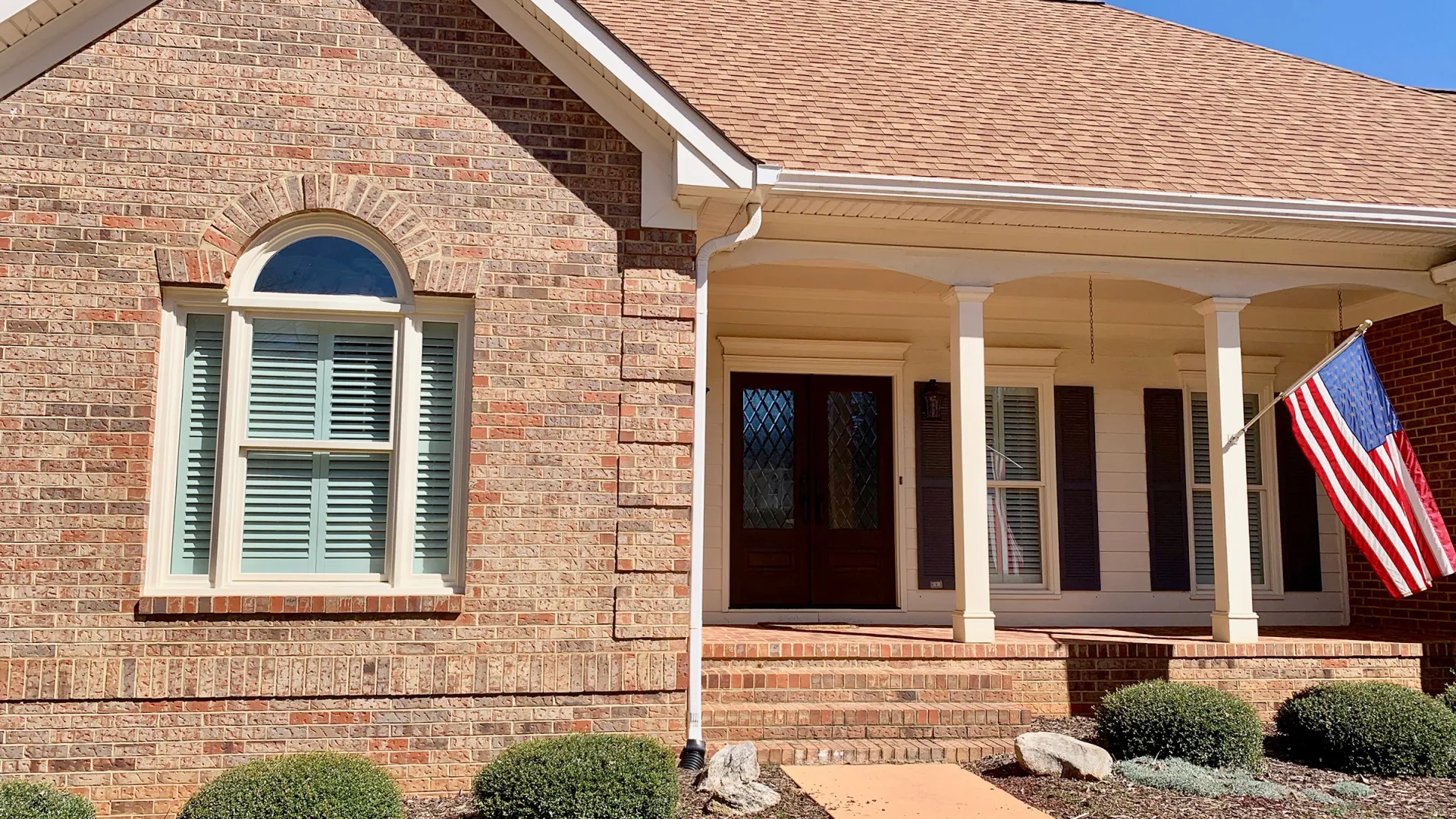 a brick house with a flag on the front