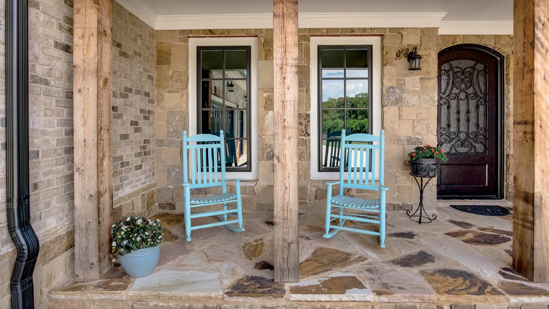 Stone front porch with two bronze casement windows.