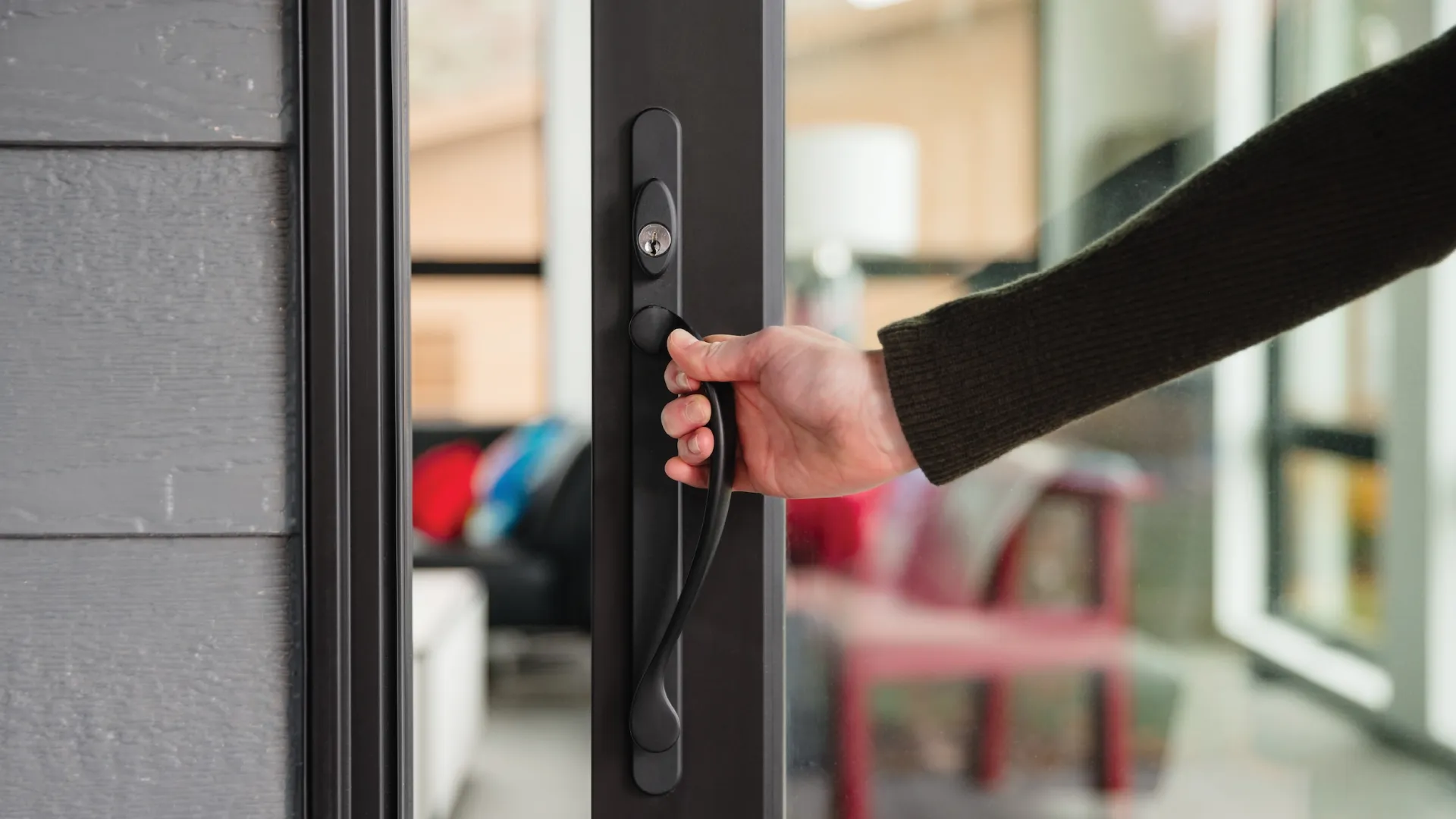 a hand holding a black door handle