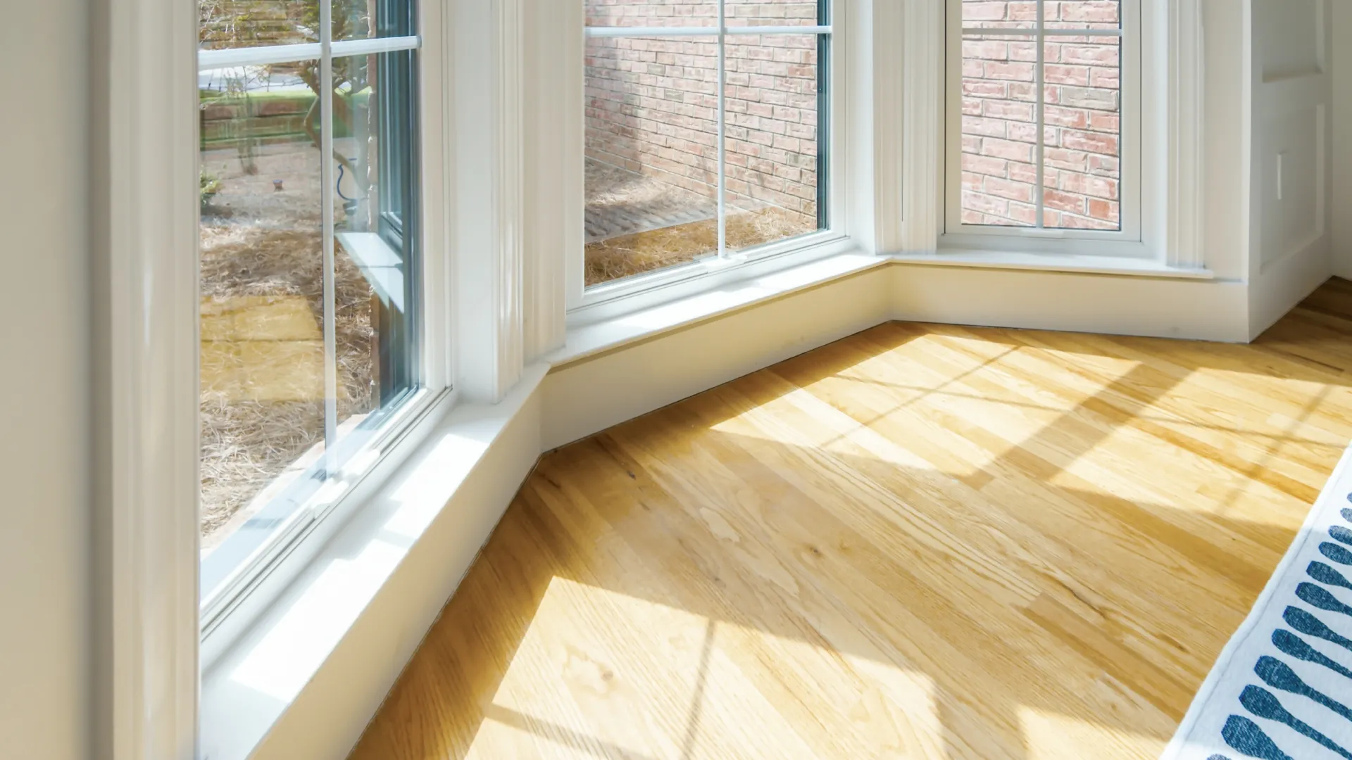 a room with a wood floor and windows