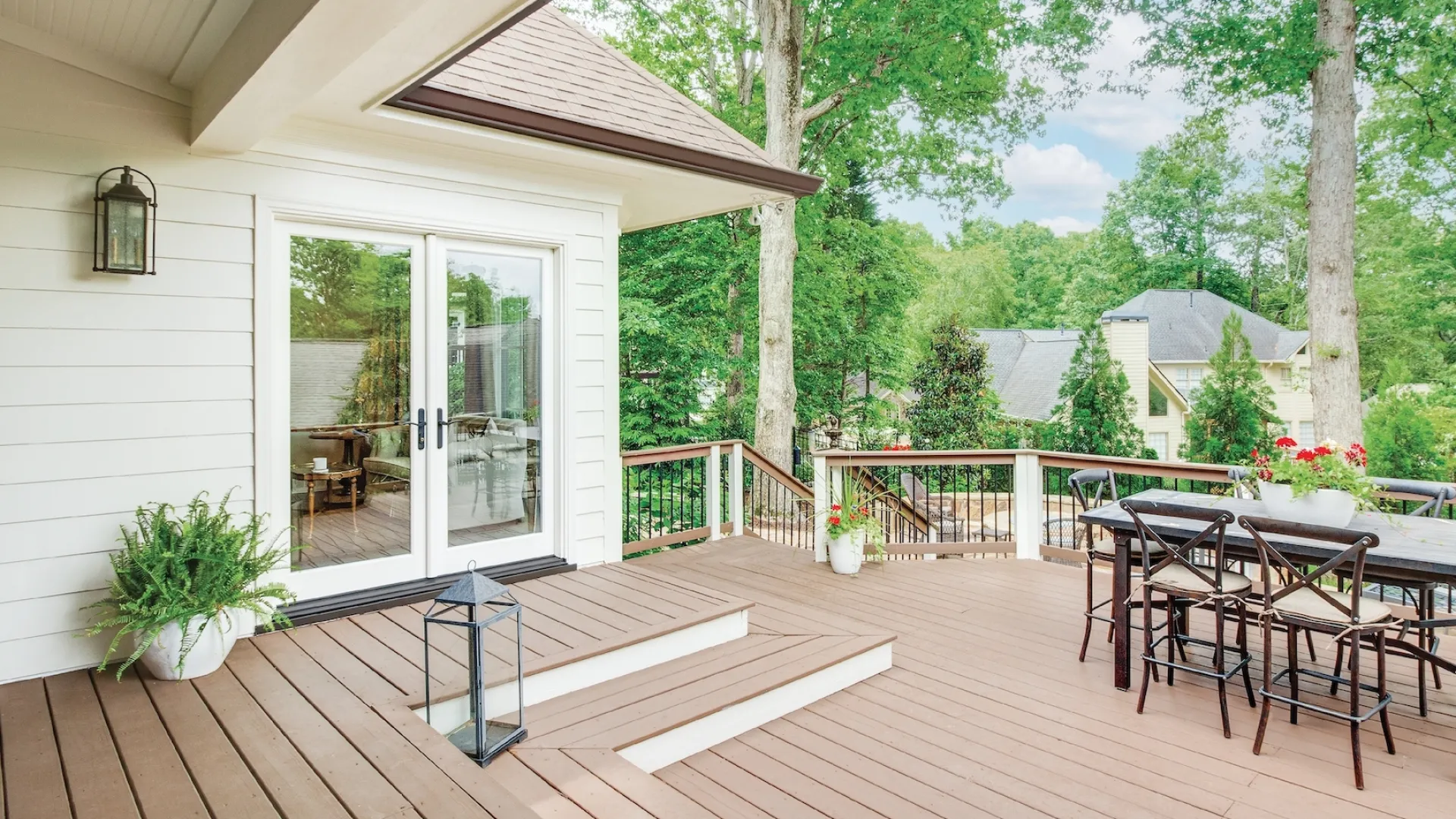 A large deck with white French doors leading into the house