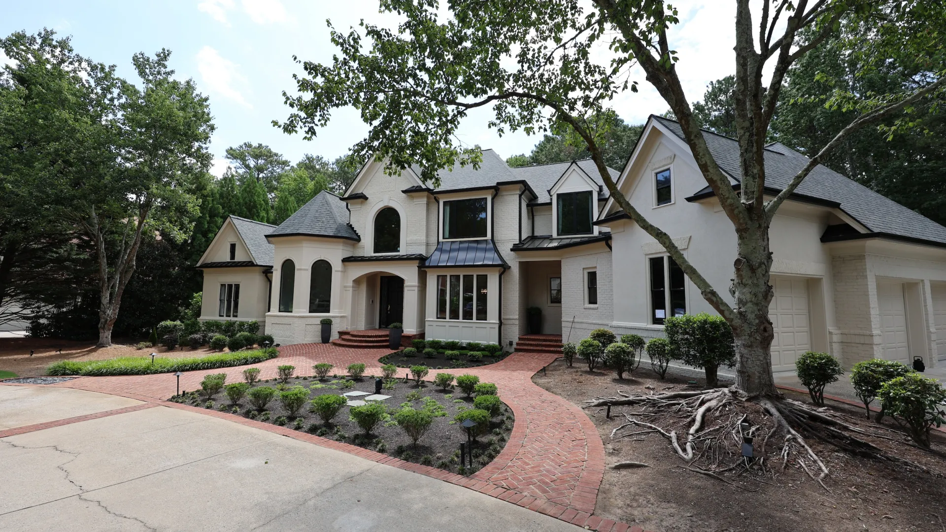 An Alpharetta, GA house with black roof, half circle planter and front brick walkway with black fiberglass replacement windows and doors from North Georgia Replacement Windows