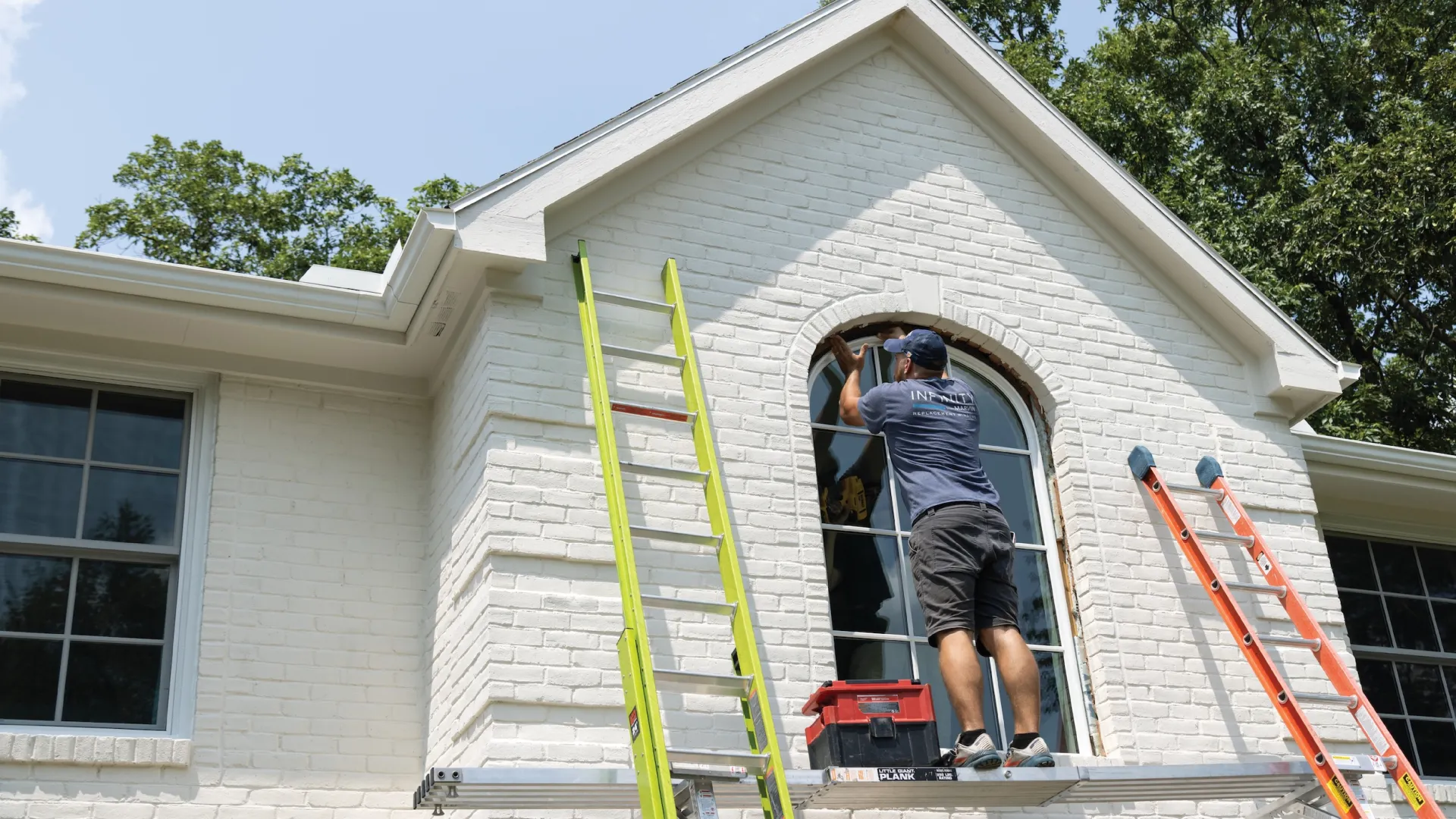 a person on a ladder painting a house