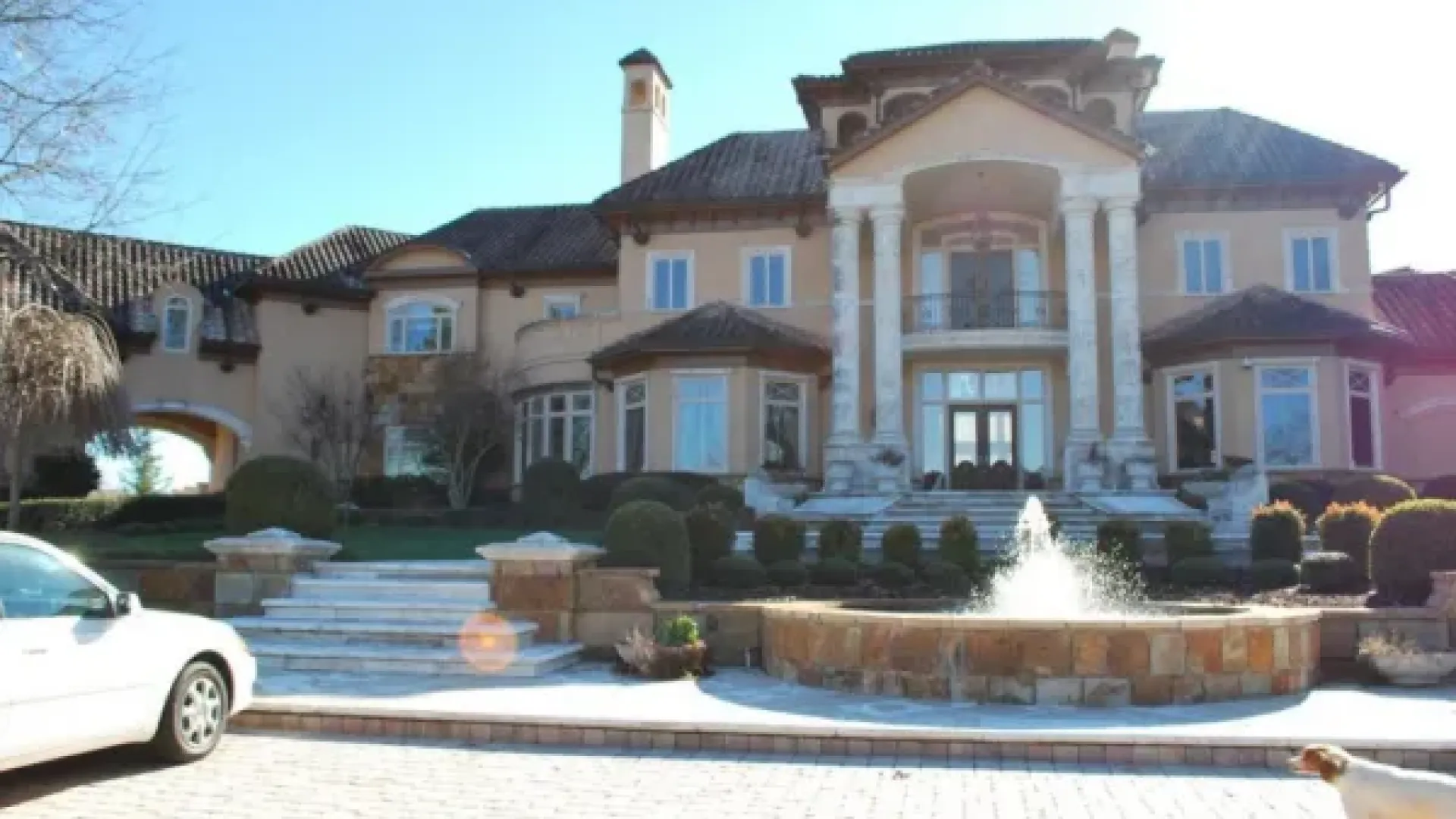 a large house with a fountain in the front