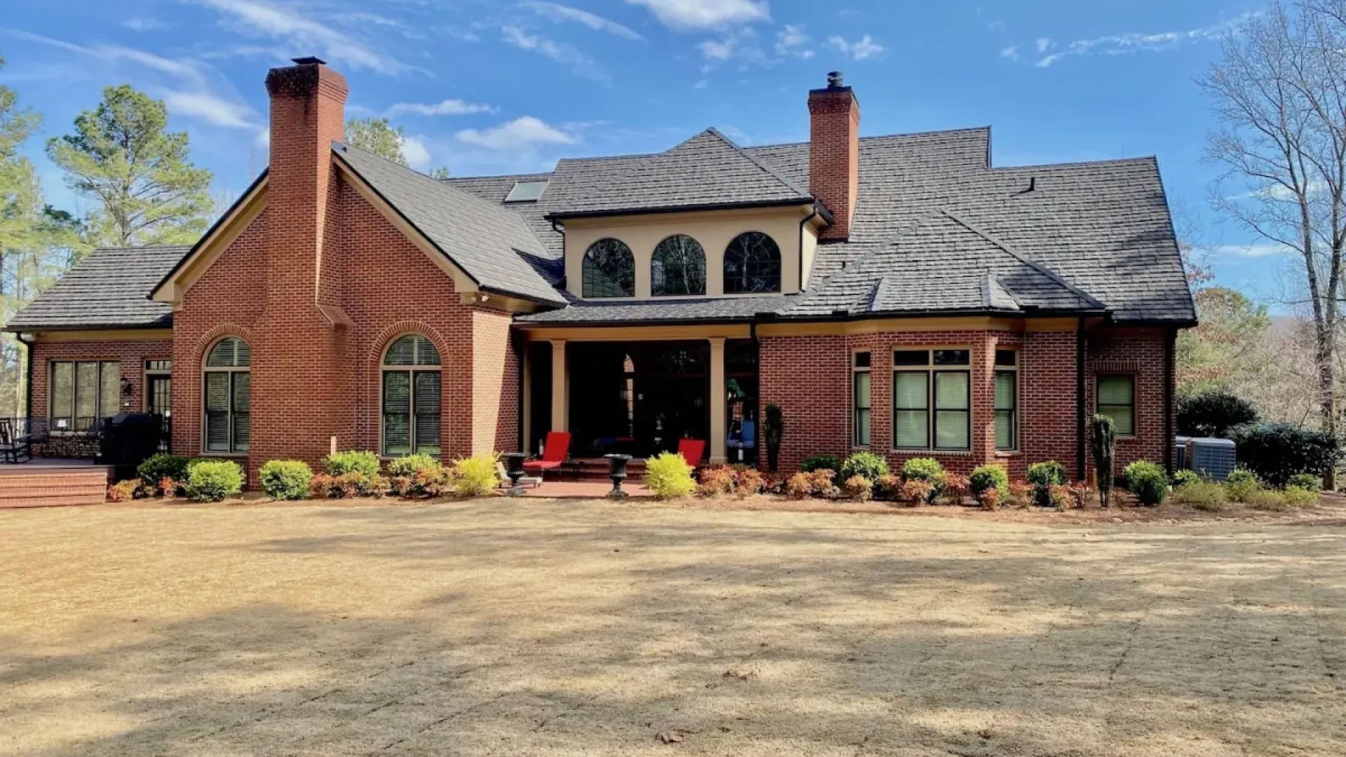 a brick house with a large front yard with Nebraska Governor's Mansion in the background