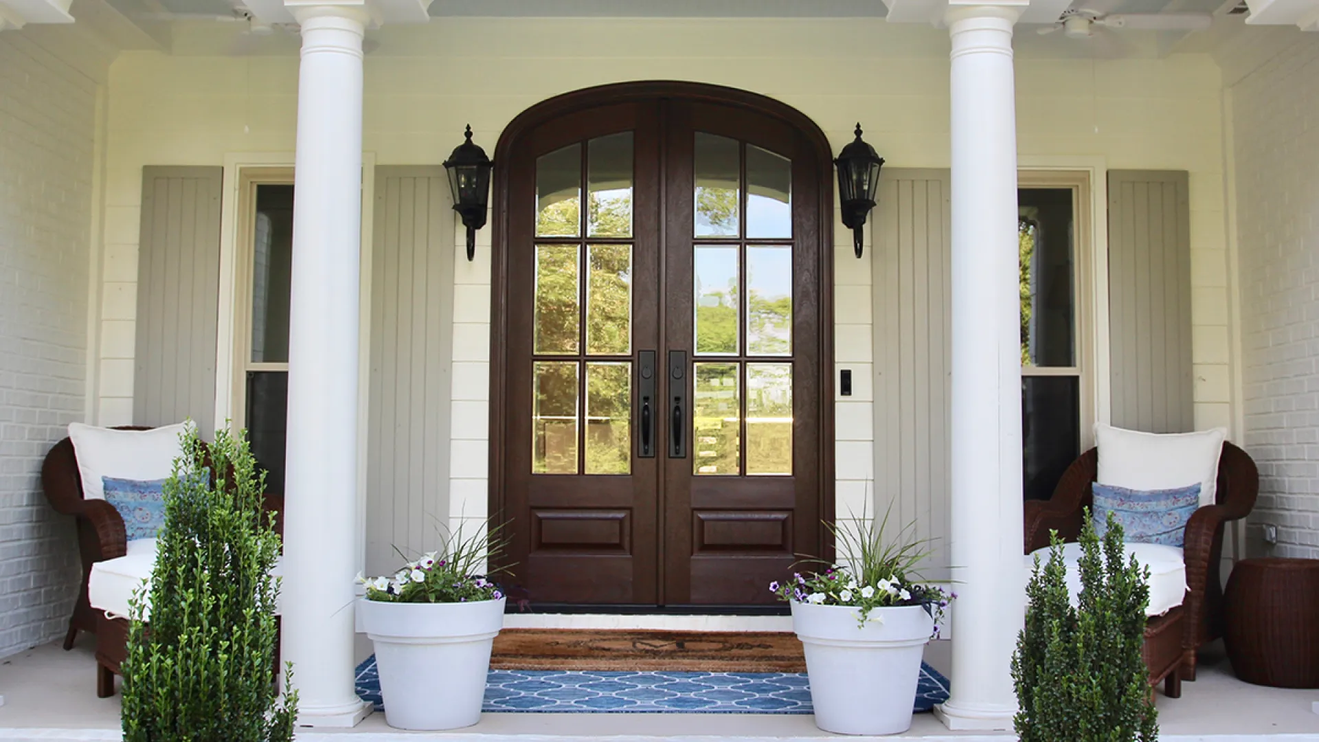 a room with a large door and white pillars