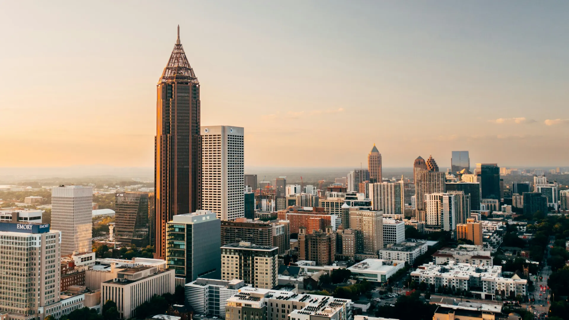 Aerial view of Atlanta skyline at sunset with iconic skyscrapers and cityscape under a clear sky.