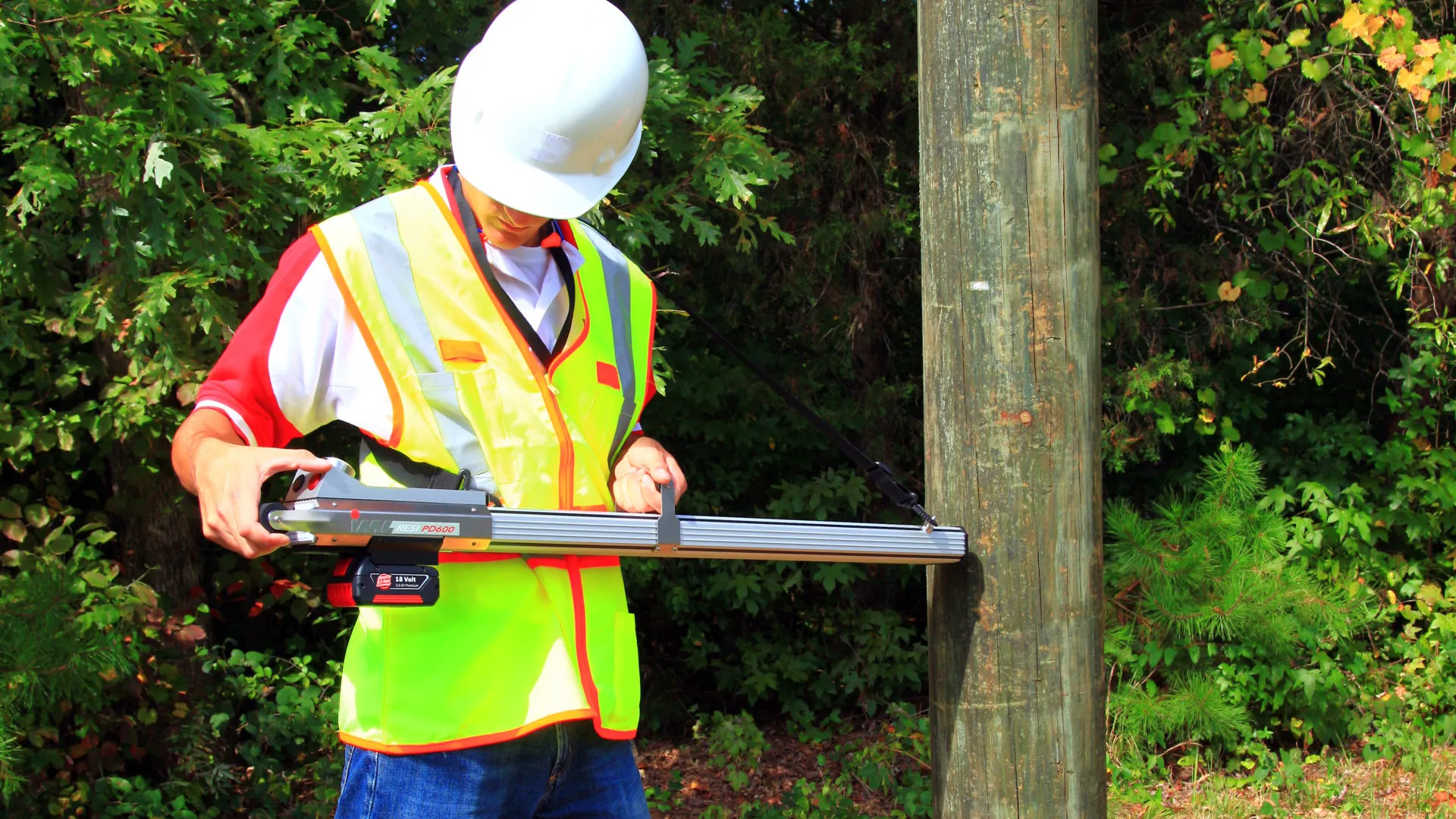 a man wearing a safety vest holding a large gun