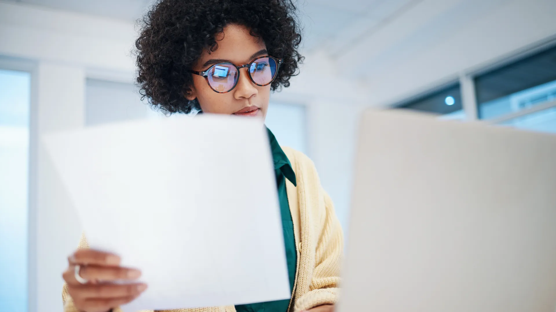 a person wearing glasses and looking at a laptop