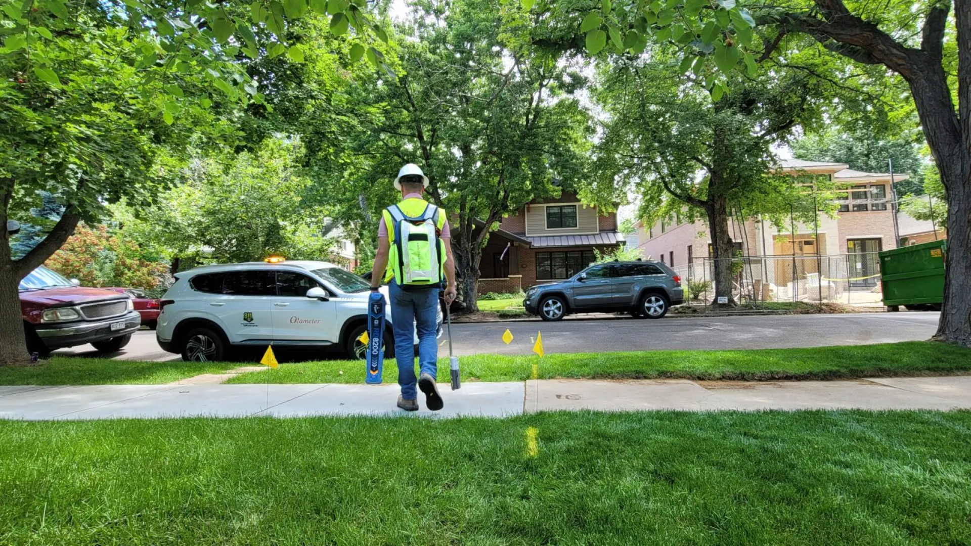 a person in a safety vest walking on the sidewalk