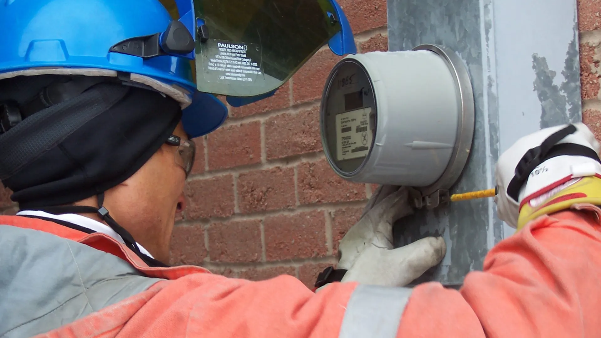 a man wearing a helmet and gloves holding a metal cylinder