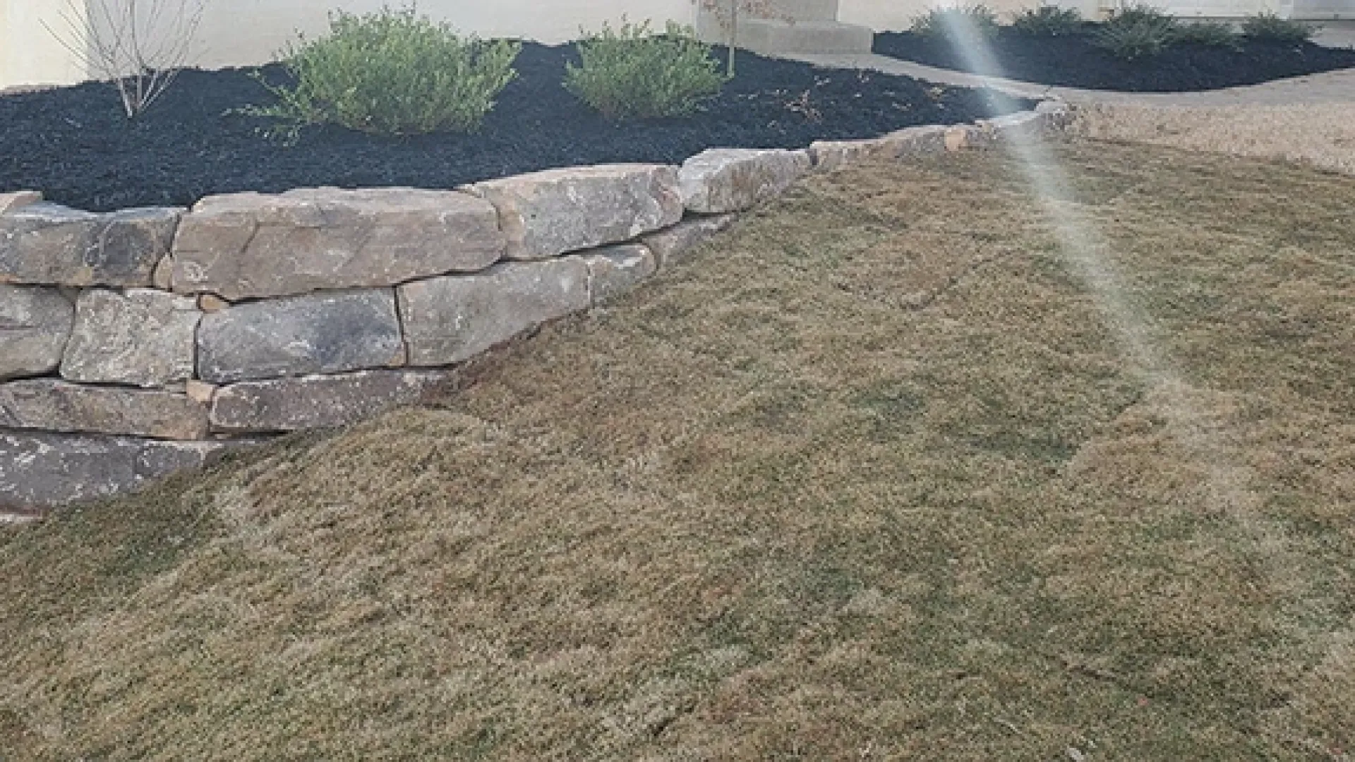 a stone wall in a grassy area