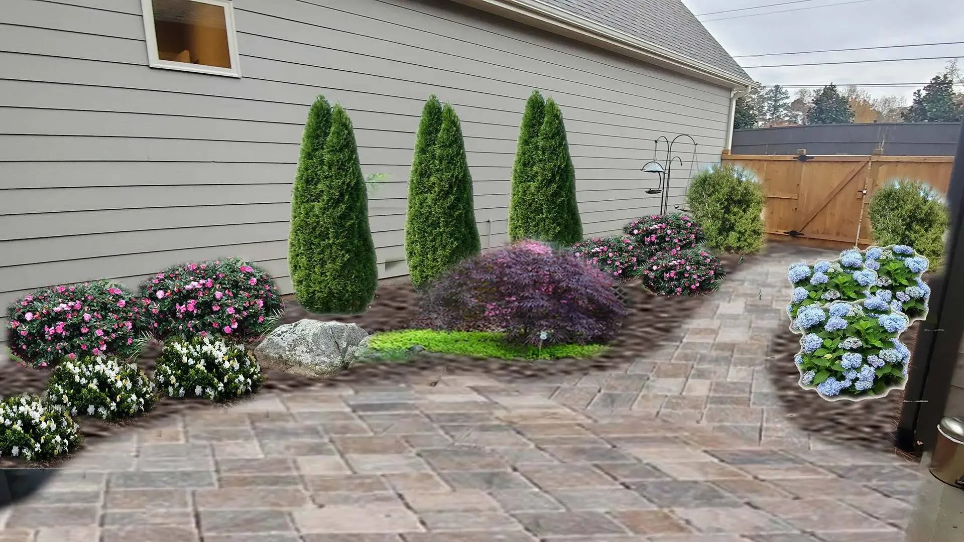 a house with a brick driveway and plants in the front