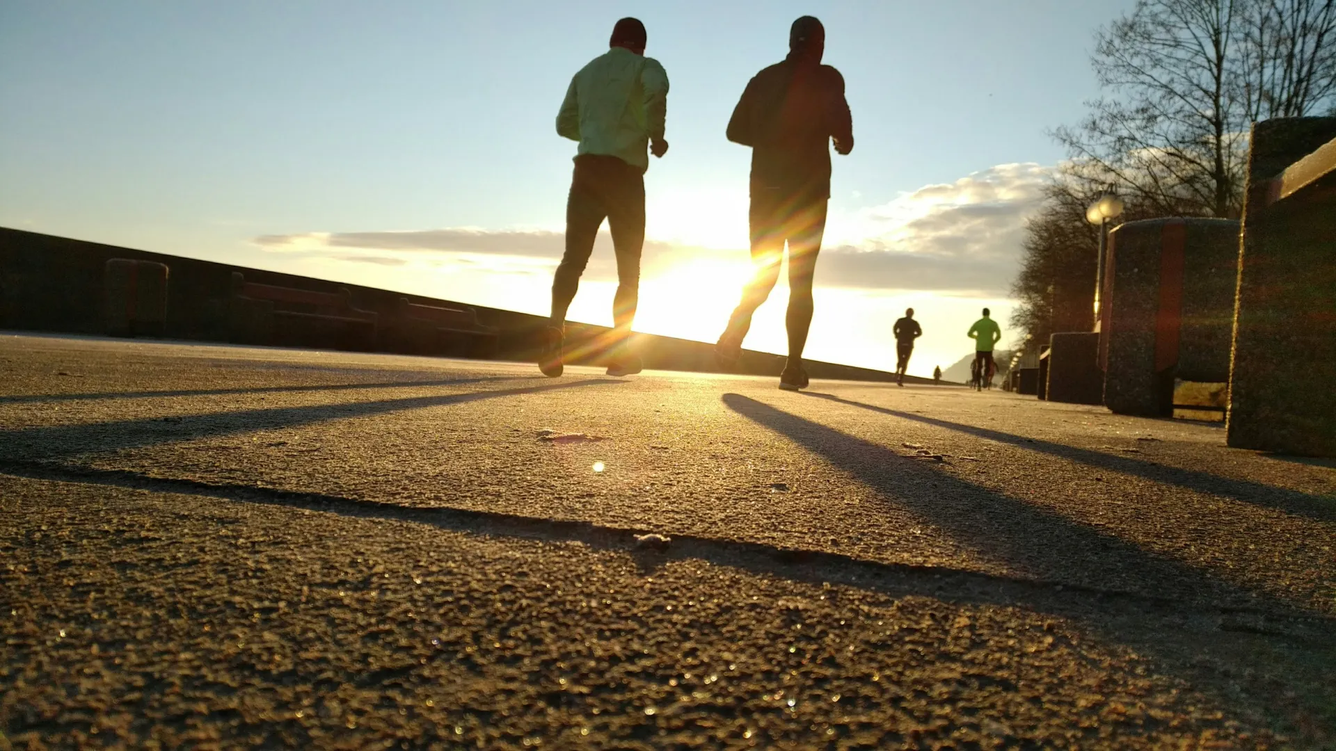 a group of people walking on a street at sunset