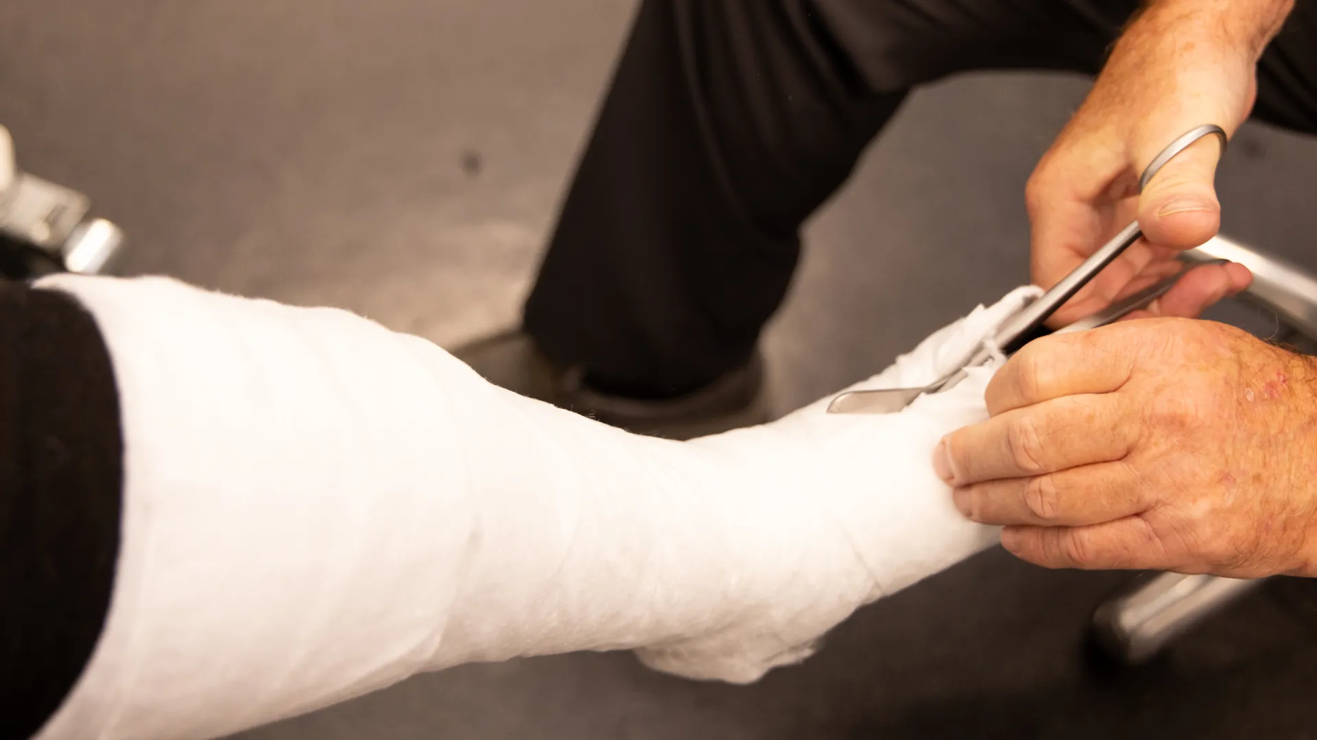 A medical professional applying a cast to a patient's leg, highlighting patient care and orthopedics.