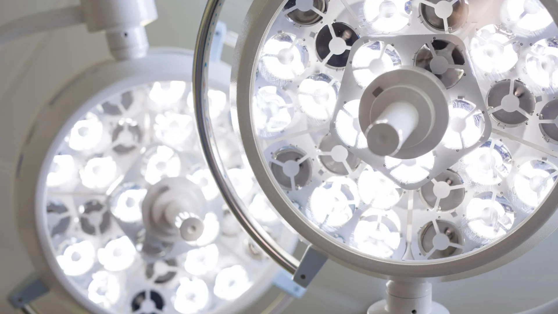 Close-up of bright LED surgical lights in an operating room, highlighting light panels and fixtures.