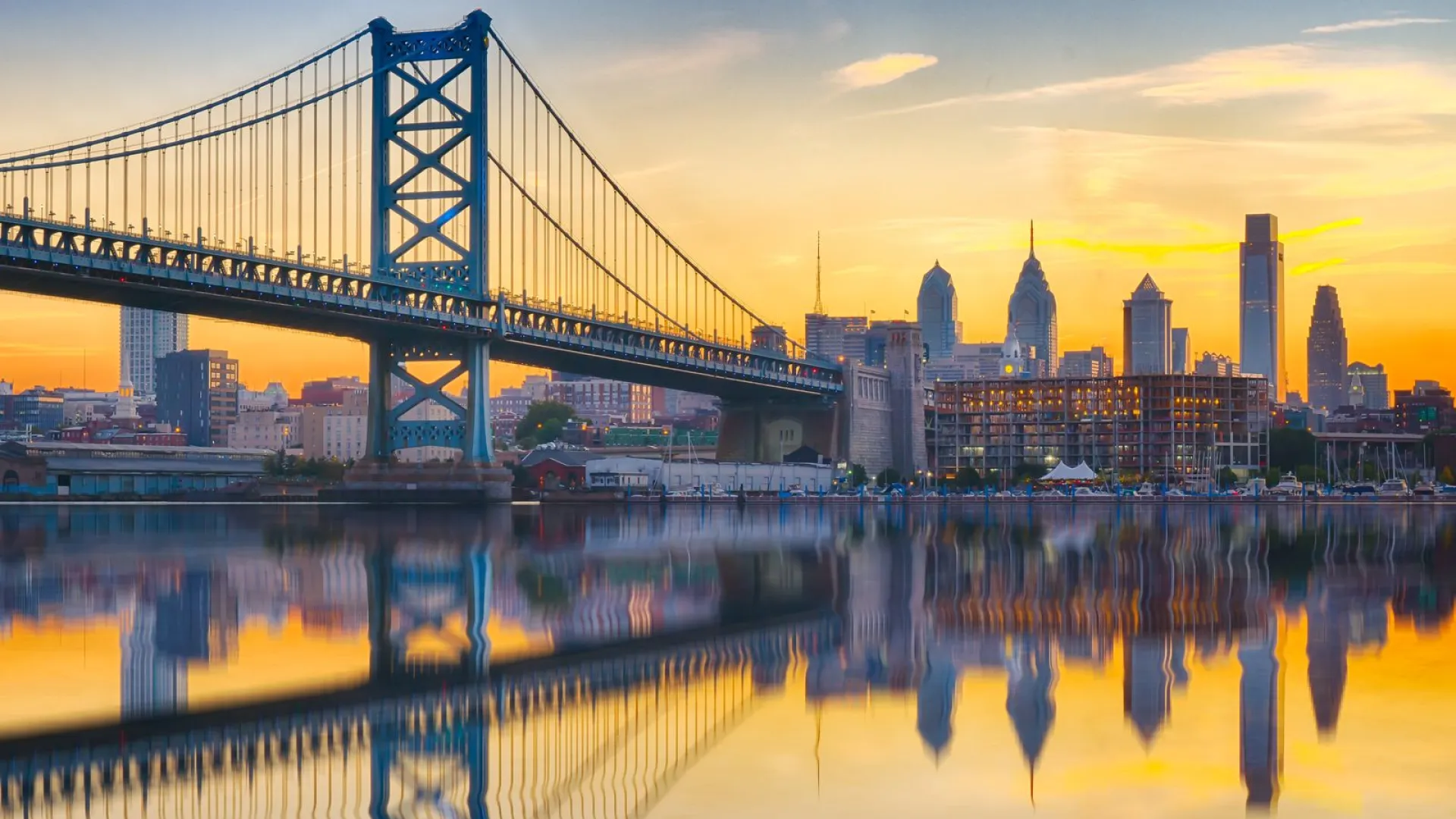 a bridge over water with a city in the background